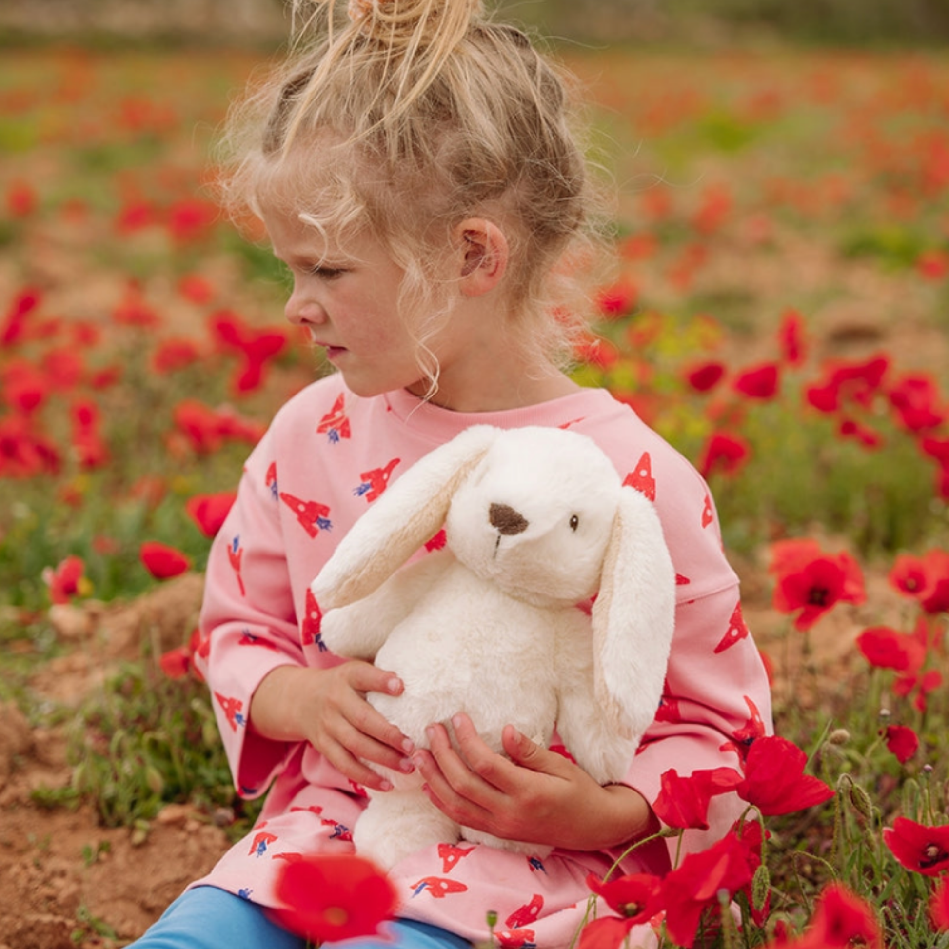 Small girl holding Bon Ton Toys Robert Rabbit 29cm Beige outdoors in poppy field lifestyle shot