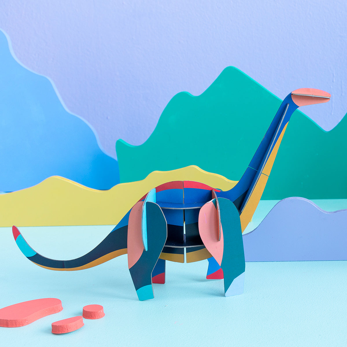 Close up of Studio Roof A4 creative play card diploducs standing on blue floor and purple background with coloured mountains 