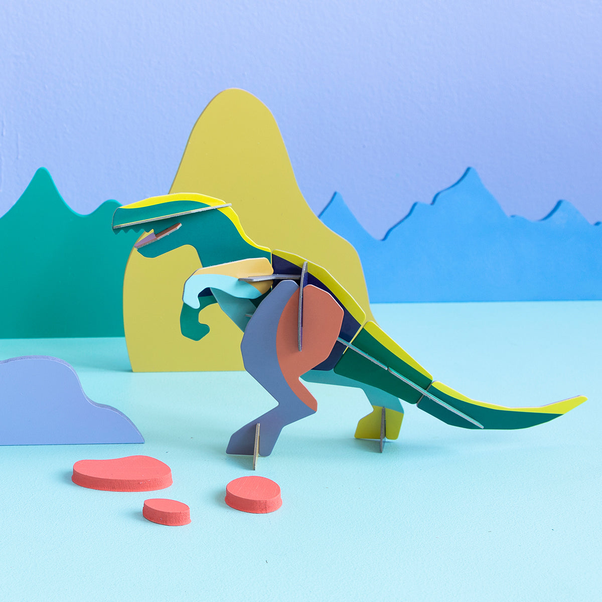 Studio Roof A4 creative play card t-rex standing on blue floor with peach stones in front of purple green and blue background white lines