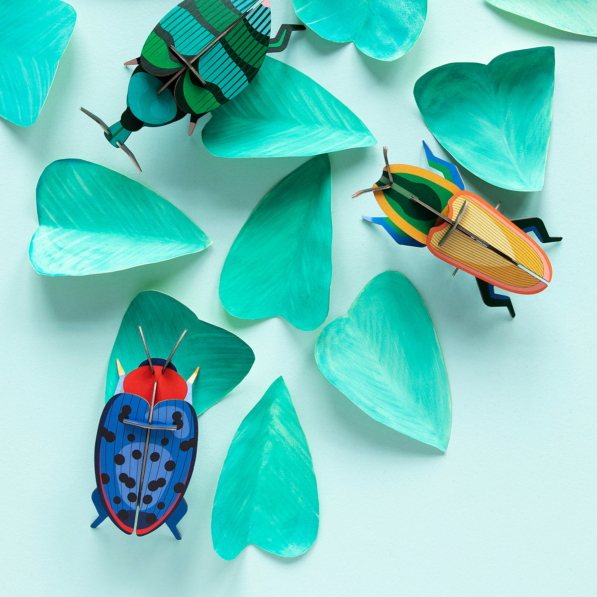 Studio Roof B7 madagascar beetle wall art and two bugs climbing on green leaves on pale green background 