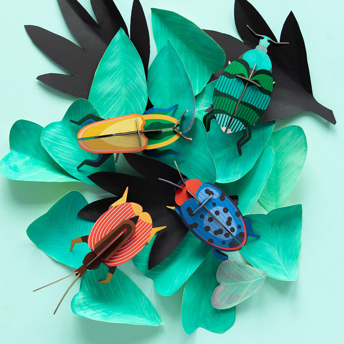 Studio Roof B7 madagascar beetle wall art climbing on green leaves with other bugs on pale green background 