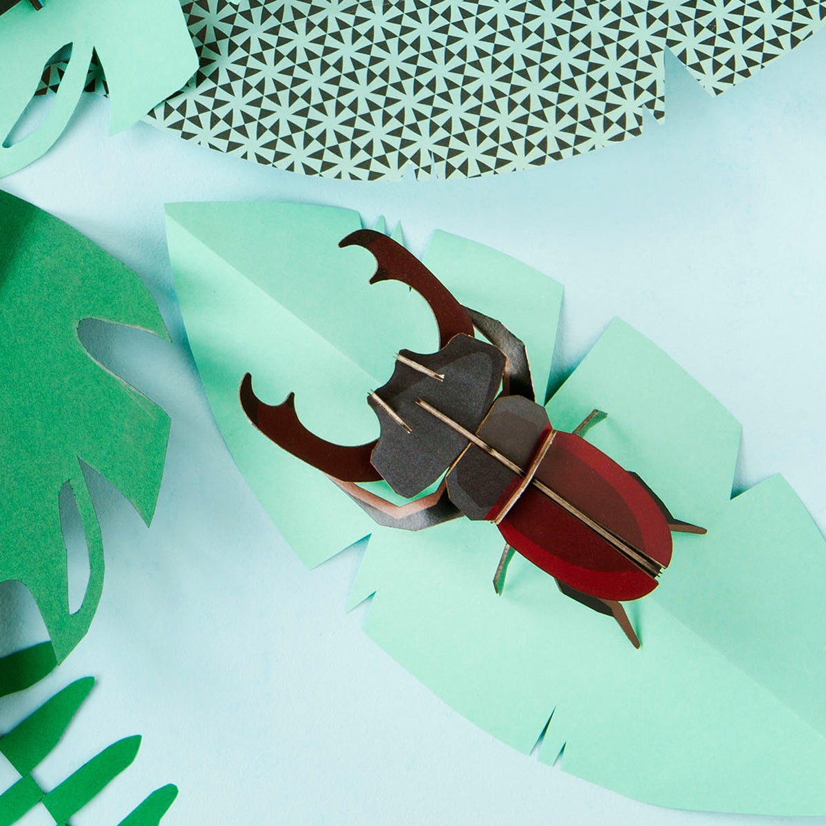 Studio Roof B7 stag beetle wall art on green leaf on pale green background