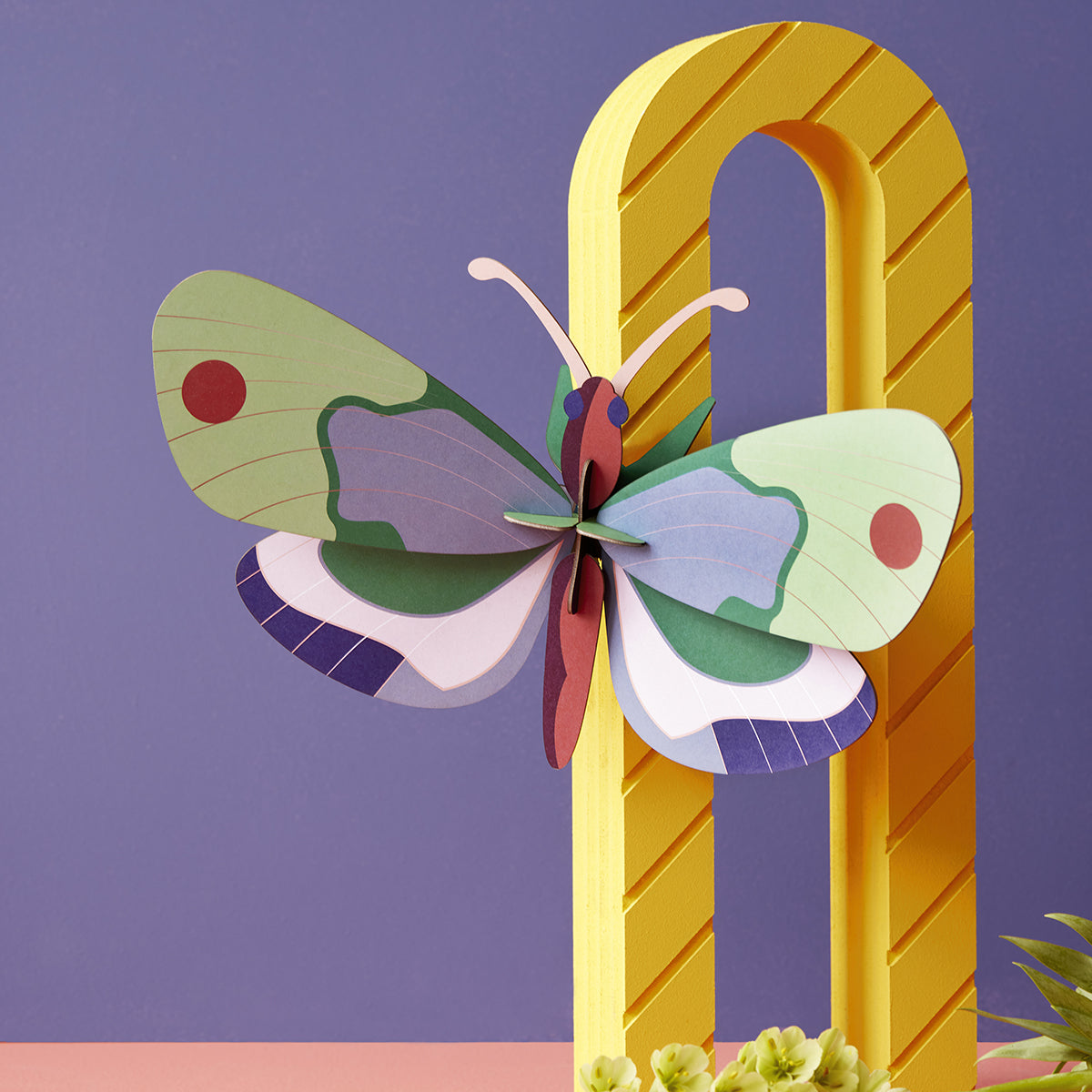 Studio Roof A4 mint forest butterfly wall art climbing on bright yellow curve in front of bright purple wall