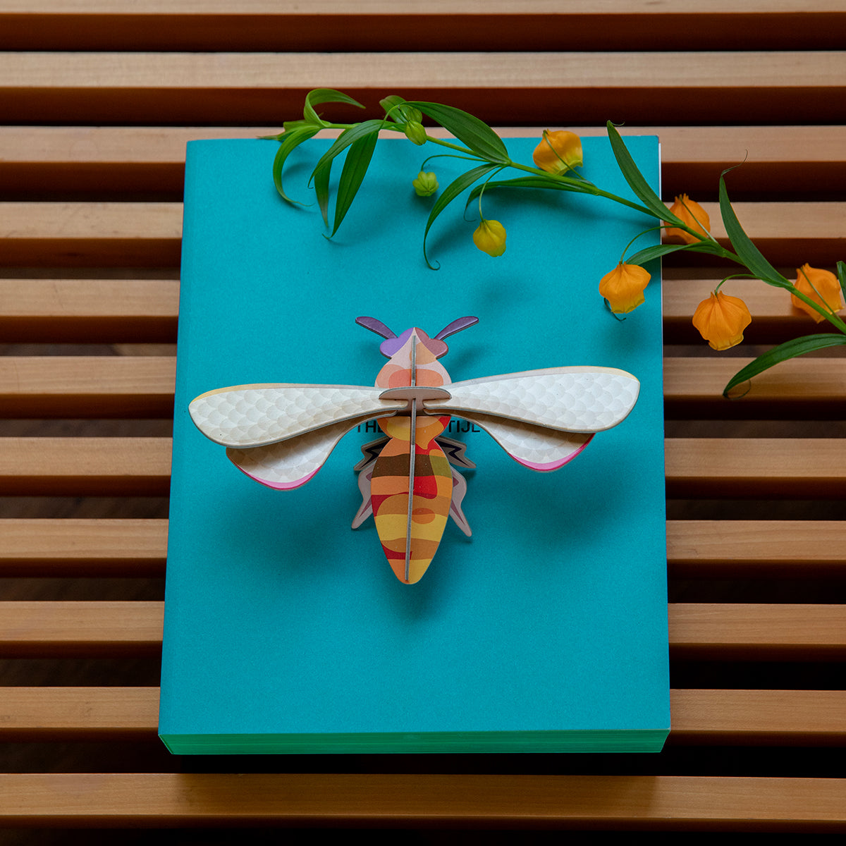 Studio Roof B7 honey bee wall art on aqua board with orange sprigs of flowers