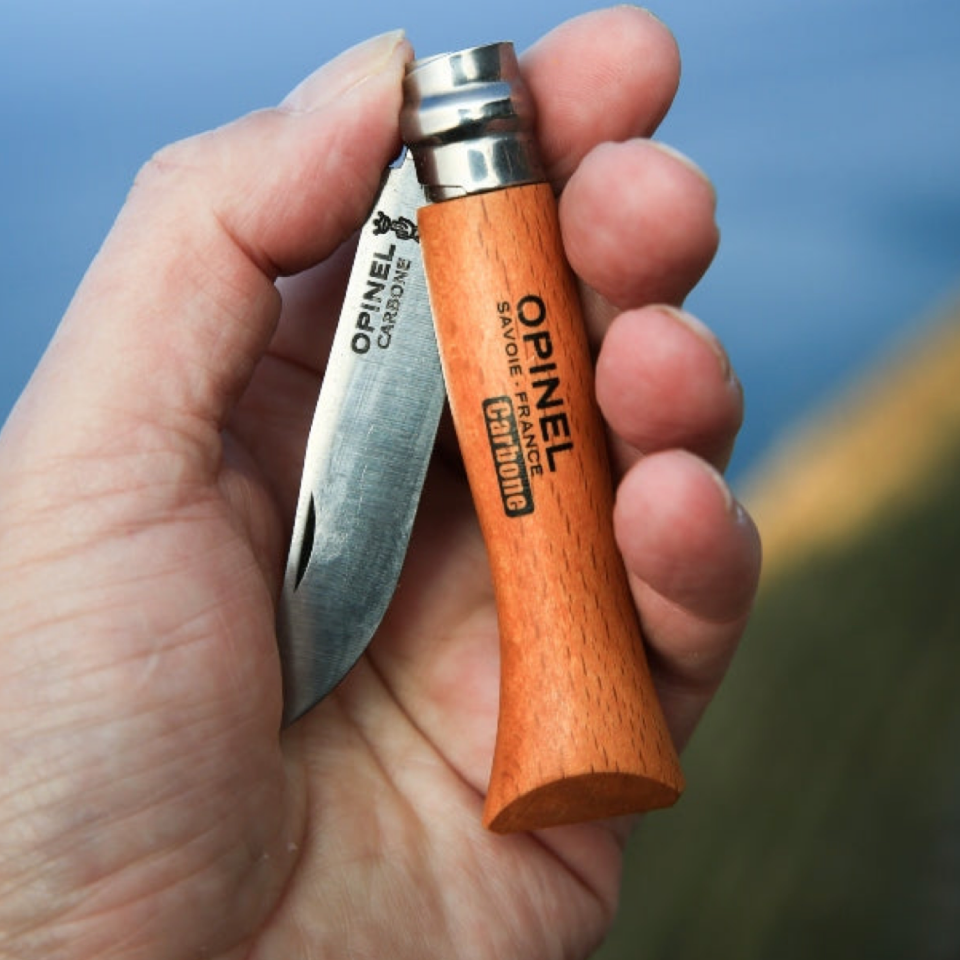 Opinel Traditional Folding Knife No6 Carbon Steel Beech half folded in mans hand outside