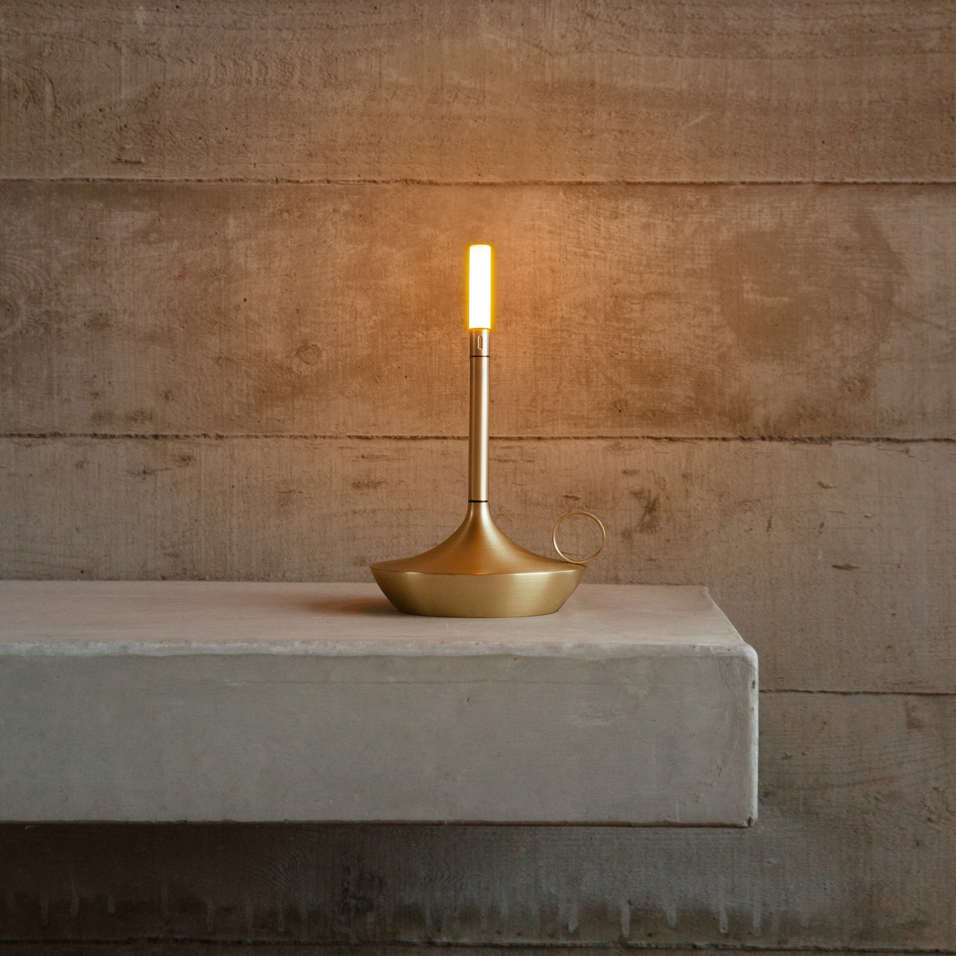 Retro LED lamp in style of candlestick with brass finish displayed on bench