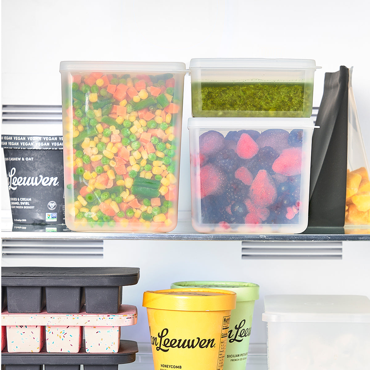 WP set of 3 freezer cubes stacked in a freezer above ice trays and icecream.