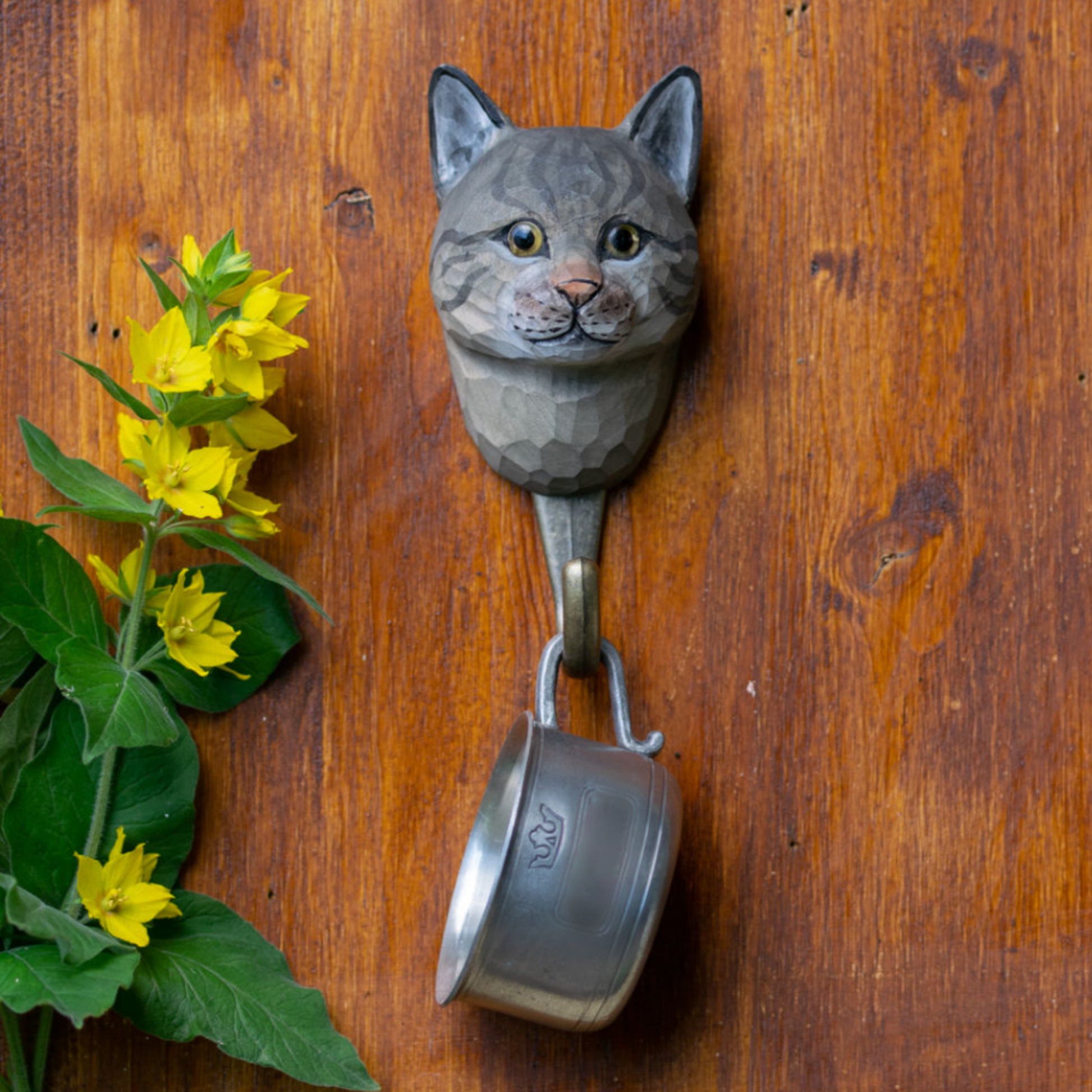 Close up of Wildlife Garden Wall Hook House Cat hanging on wooden wall holding cup on hook 