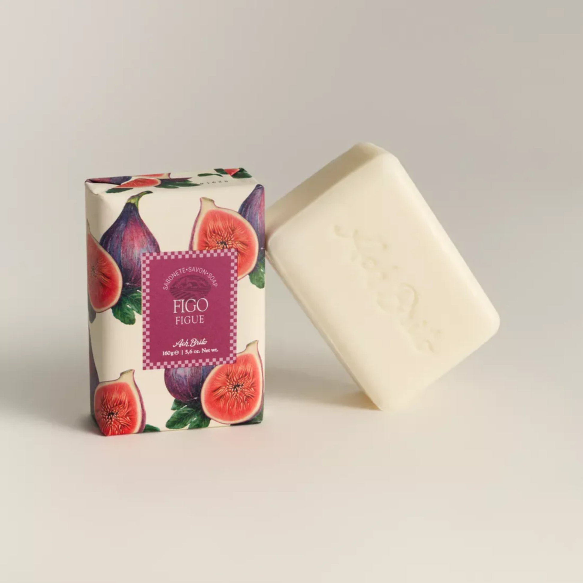 Soap and packaging view of Ach. Brito Vegetable Soap 160g, fig-scented light beige bar made with a vegetable base and sweet almond oil, produces creamy lather, eco-friendly, suitable for daily bath or kitchen hand hygiene.
