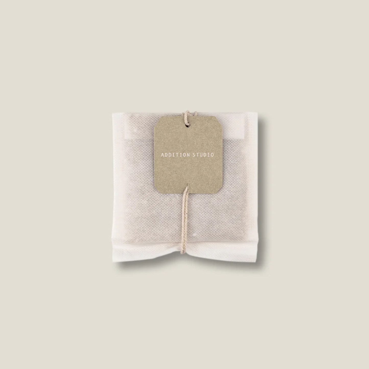 Upclose view of the tea bath bag of the Addition Studio Bath Brew Milk 75g with Epsom salt for relaxation, goats milk, raw organic cocoa butter and lavender scent.