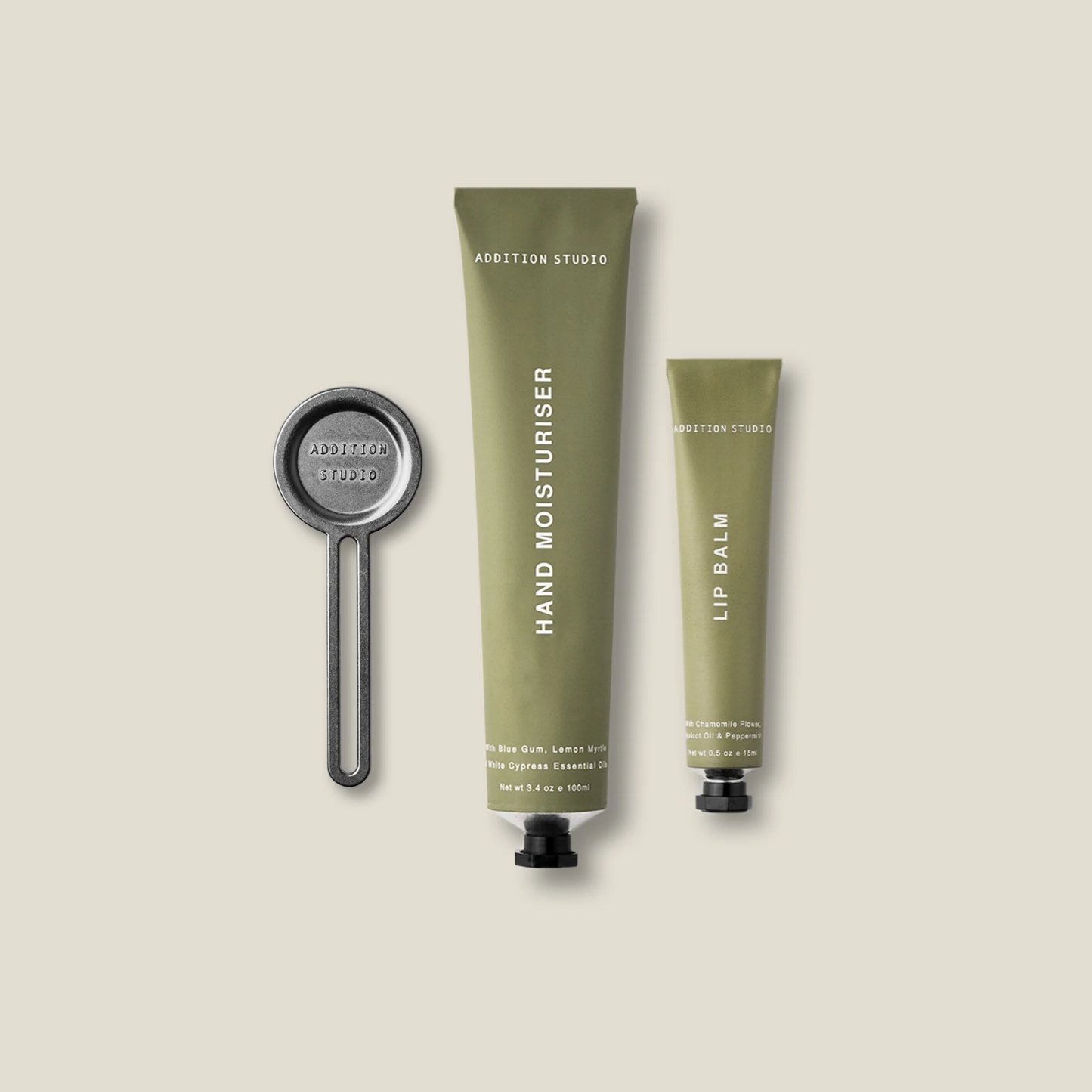 Front view of the 3 things inside the Addition Studio Squeeze the Day Set that Includes Hand Moisturiser (100ml) and Lip Balm (15ml) with plant-based formulas and 100% natural essential oils. Features aluminium tubes with a zinc alloy tube squeezer.
