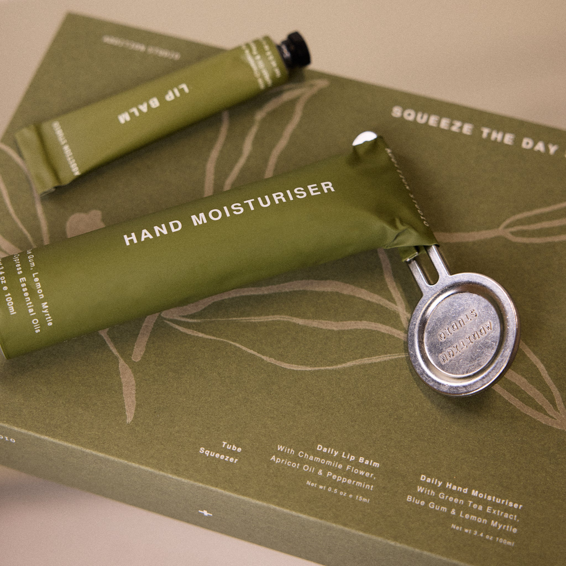 On top of its box, the Addition Studio Squeeze the Day Set: Includes Hand Moisturiser (100ml) and Lip Balm (15ml) with plant-based formulas and 100% natural essential oils. Features aluminium tubes with a zinc alloy tube squeezer.