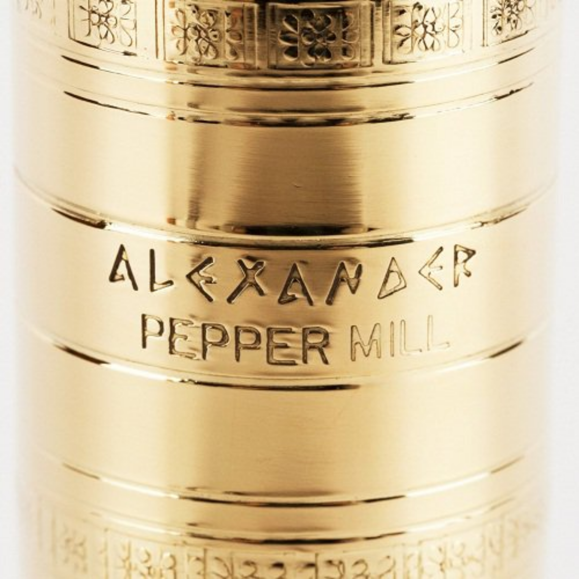 Close up view of the text from the mill that is Alexander Pepper Mill from Alexander Mills Brass Pepper Mill #104 - Brass, 230mm / 9" tall, 3DCut metal grinding system, adjustable coarse-fine, handcrafted Greek, durable polished body, easy-grind long arm, open-bottom flanged base, ideal for pepper seasoning, kitchen tool, flavor-maximizing grinder.