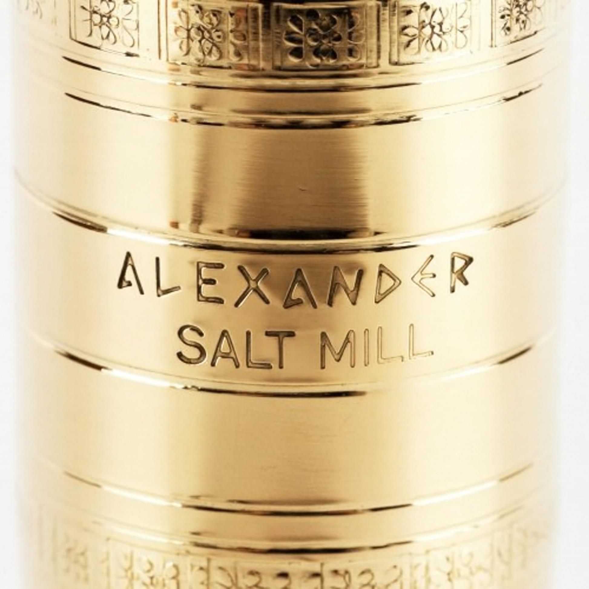 Closeup of Alexander Mills salt grinder showing engraving and pattern on the brass body.