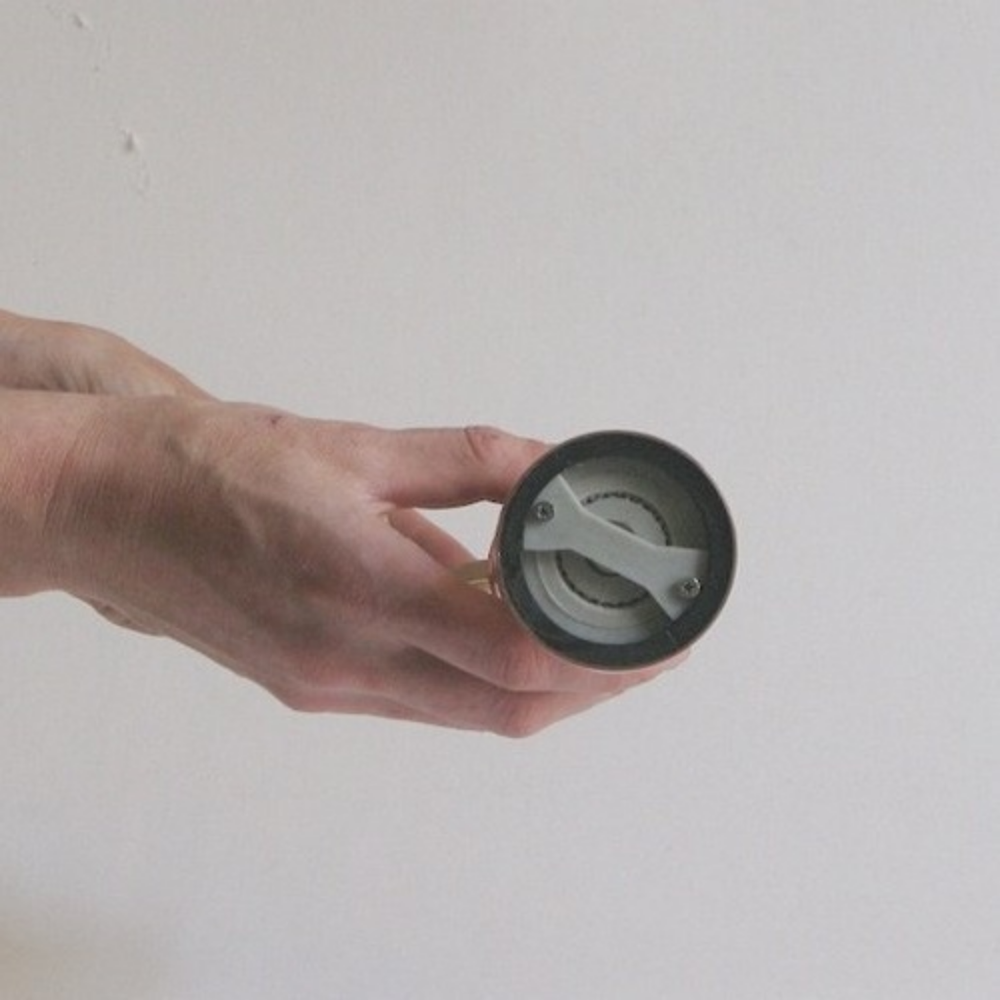 Showing the bottom part of the salt mill from Alexander Mills Brass Salt Mill #109 - Brass, 230mm / 9" tall, 3DCut food-safe plastic (40% glass) grinding system, stainless-steel shaft, adjustable fast salt grinding, handcrafted Greek, durable polished body, easy-grind long arm, open-bottom flanged base, kitchen tool, flavor-maximizing mill, pairs with pepper mill #104.