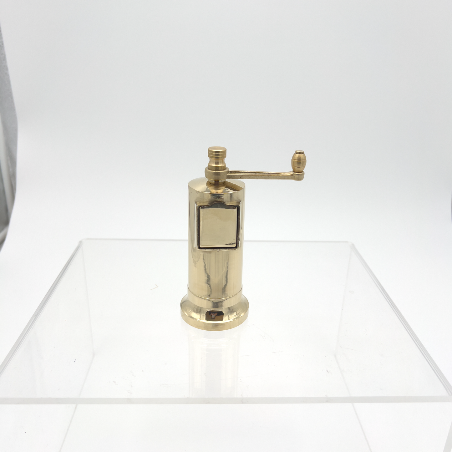 Front view on a surface Alexander Mills Cast Brass Pepper Mill #006 - Cast brass, 135mm / 5.3" tall, 3DCut metal grinding system, adjustable coarse-fine, side refill socket, handcrafted Greek, durable polished body, easy-grind long arm, open-bottom flanged base, kitchen tool, flavor-maximizing pepper grinder.