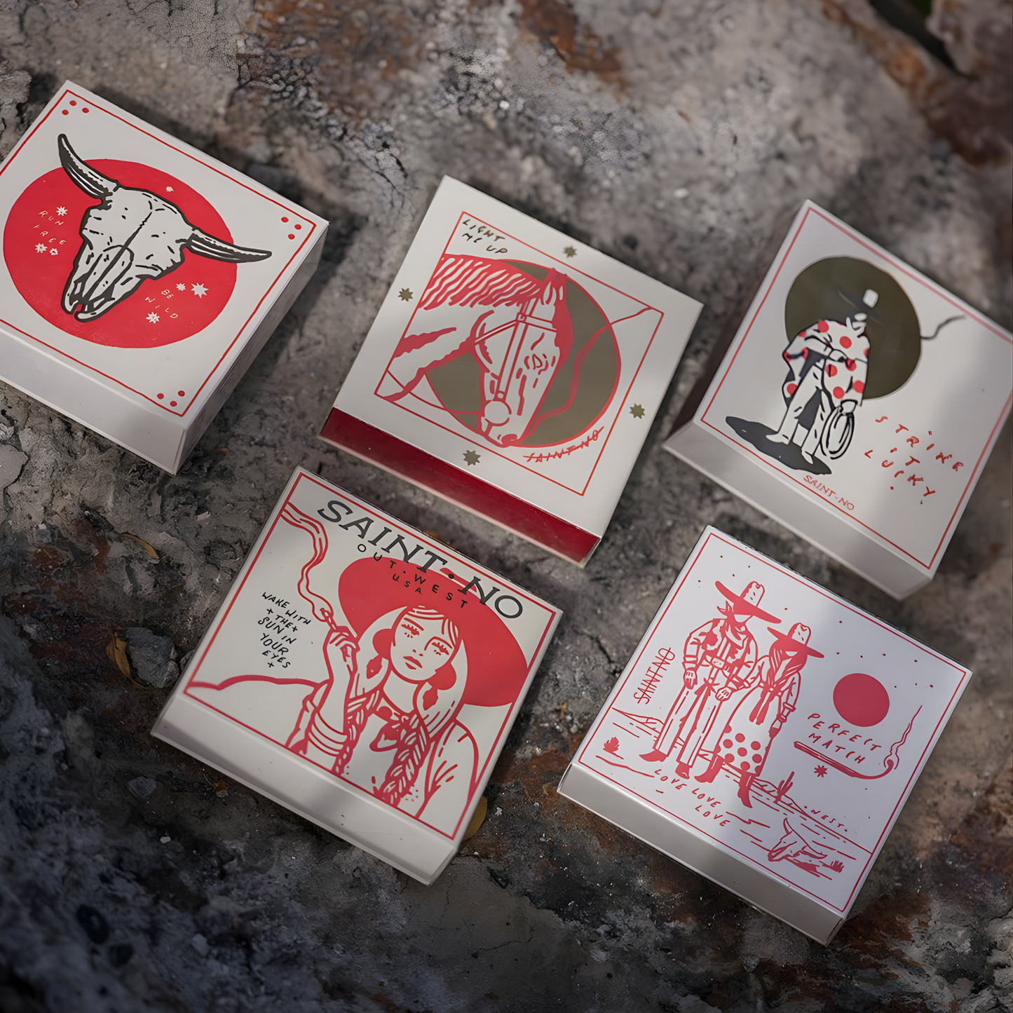 Showing cowboy design related matchboxes with the Archivist Luxury Matches Cowboy Perfect Match: Features a Western scene of a cowboy and cowgirl beneath the sun with the words "Perfect Match, Love love, love." Contains 125 matches (100 mm, red tips), letterpress printed in the UK with FSC-certified wood and wrapped in compostable cello-perfect for coffee tables, mantelpieces, or gifting.