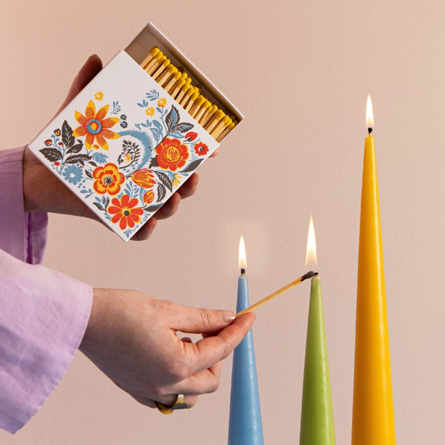 Showing candles being lit using the Archivist Flower Matches - Square Matchbox with Colourful Floral Design and White Tray - 125 Natural Yellow-Tipped Matches - FSC Wood, UK Letterpress Printed, Eco-Friendly Decorative Match Set