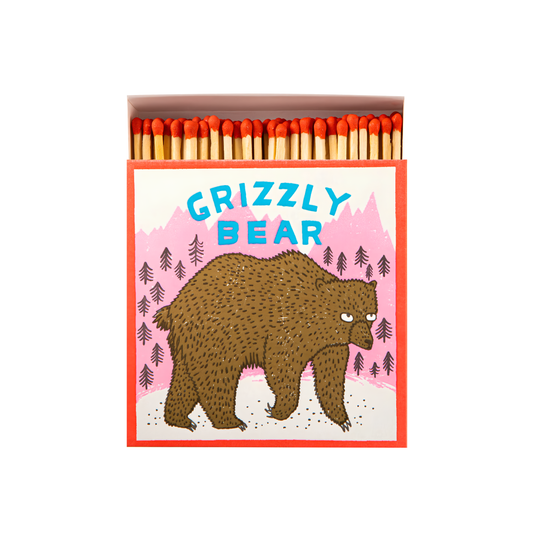 Front view of Archivist Luxury Matches Grizzly Bear in brown, black and pink, FSC Mix certified paper matchbox with grizzly bear and mountain illustrations, containing 125 natural wooden matches with red tips.