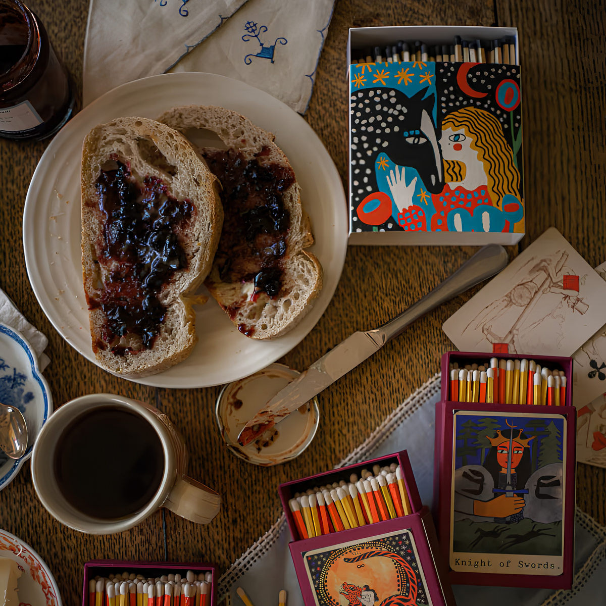 Archivist Luxury Matches Heart Horse in blue with a starry sky, FSC Mix certified paper matchbox featuring a girl and horse illustration, with 125 natural wooden matches and black tips, shown on the table with food and other match designs.