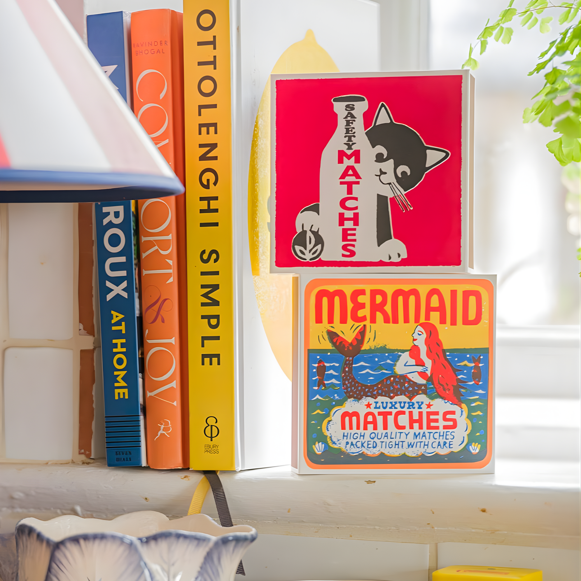 Seen standing with books on the window ledge, the Archivist Luxury Matches Mermaid which features a playful sardine tin illustration with a mermaid by The Printed Peanut. Contains 125 matches (100 mm, red tips), letterpress printed in the UK using FSC-certified wood and wrapped in compostable cello-ideal for coffee tables, mantelpieces, or gifting.