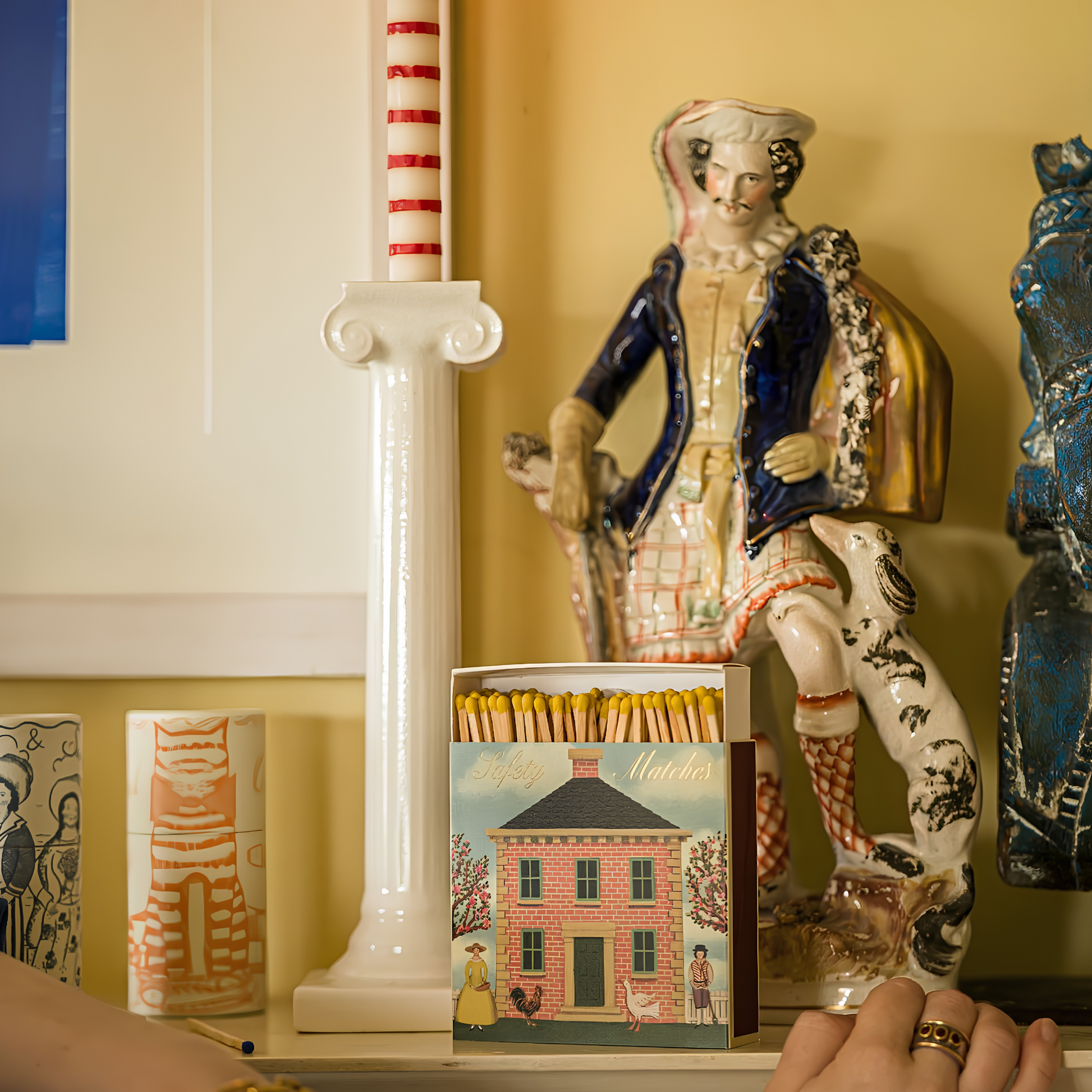 Archivist Luxury Matches featuring a Red Brick House with chicken and goose outside with the words 'Safety Matches', standing along with the candle and figurines.