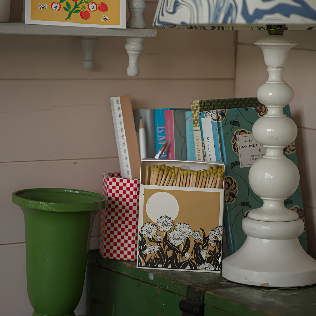 Archivist Luxury Matches Sunflower Fields in yellow and beige, FSC Mix certified paper matchbox with sunflower field illustration, containing 125 natural wooden matches with yellow tips, shown on top of a wooden cabinet with a lamp beside it.