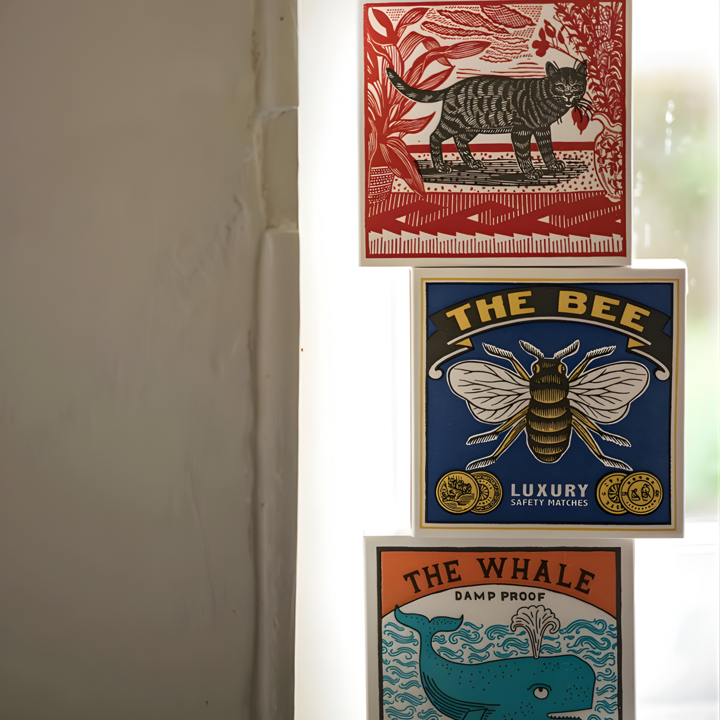 Stacked between the cat and the whale matchboxes, the Archivist Luxury Matches The Bee which features a bumblebee on a blue background with the words "The Bee, Luxury Safety Matches." Contains 125 matches (100 mm, yellow tips, white tray), letterpress printed in the UK with FSC-certified wood and wrapped in compostable cello-perfect for coffee tables, mantelpieces, or gifting.