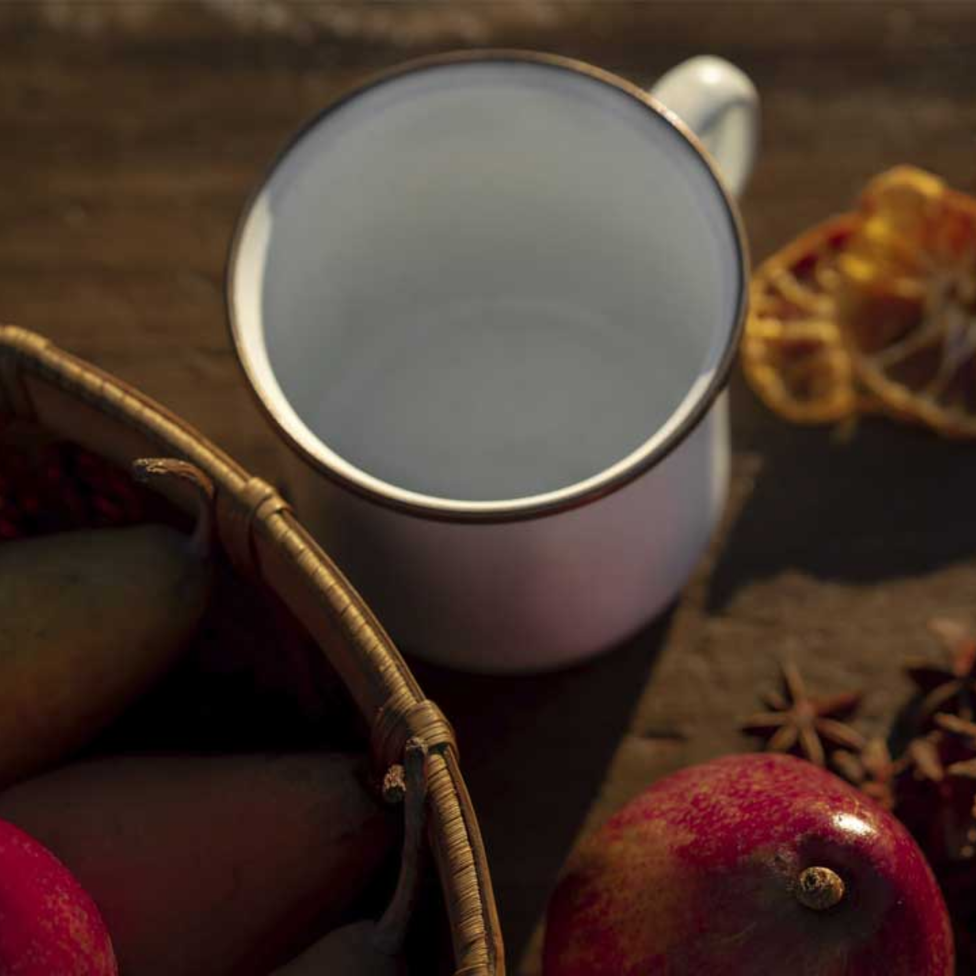 Barebones enamel cup outdoors on wooden table with pears top view