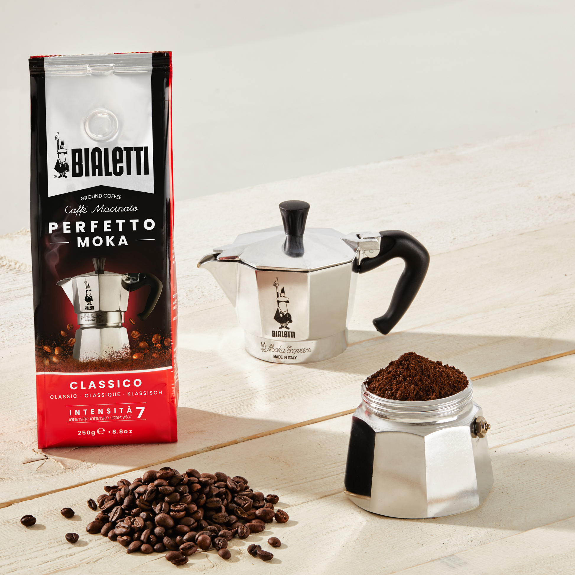 Bialetti Moka Express 3-cup stovetop espresso maker, shown with coffee inside the lower chamber, medium-small aluminum model with octagonal body, designed for brewing aromatic Italian-style coffee with intense flavor, Made in Italy.