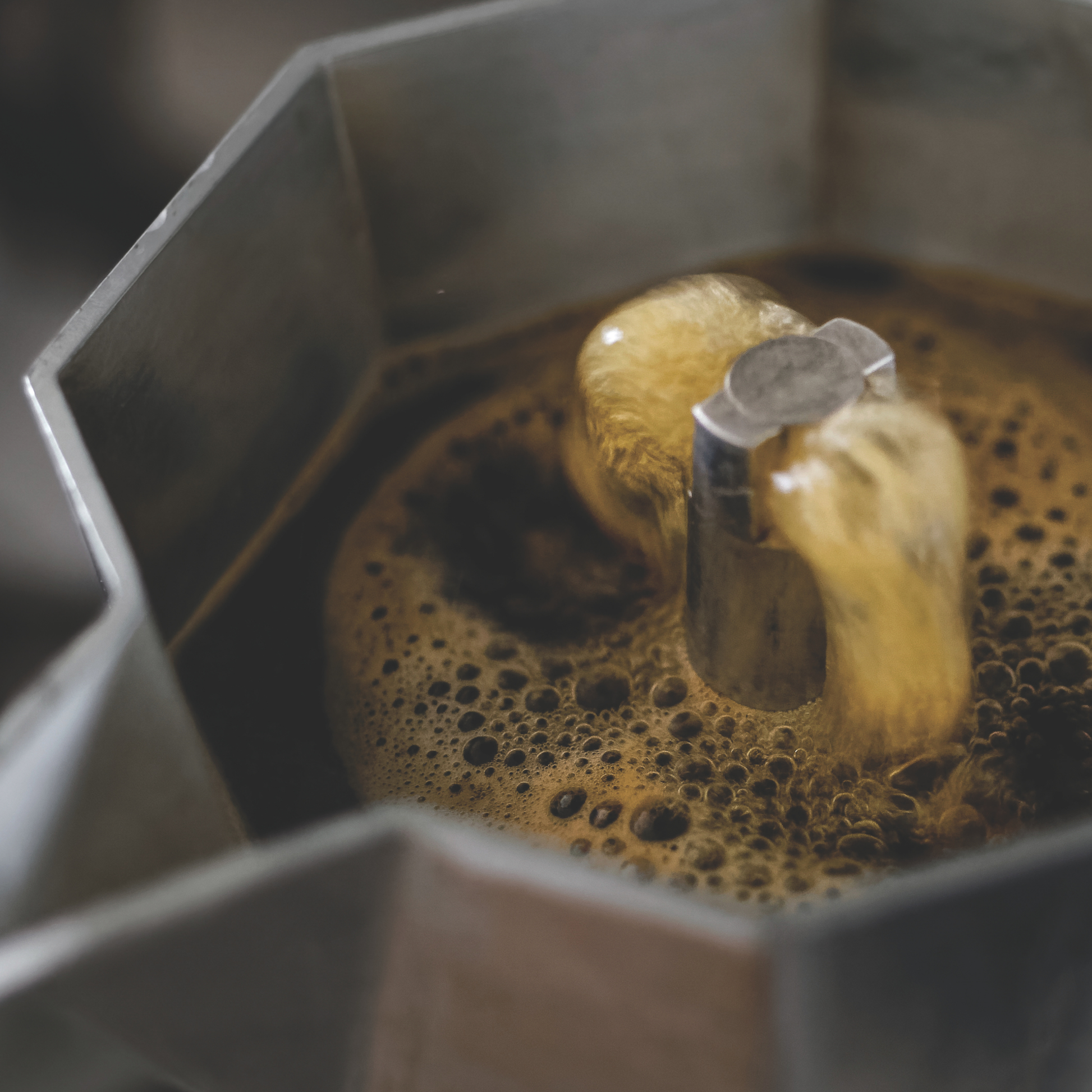 Bialetti Moka Express 3-cup stovetop espresso maker, shown with boiling coffee in the upper chamber, medium-small aluminum model with octagonal body, designed for brewing aromatic Italian-style coffee with intense flavor, Made in Italy.