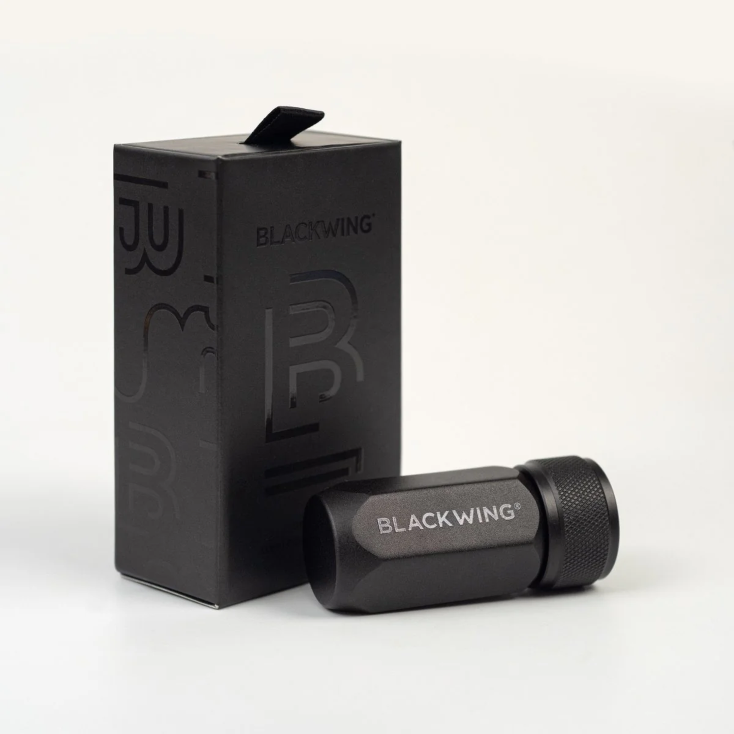 Container box with the Blackwing One-Step Long Point Sharpener in black machined aluminum with German steel blade - compact, pencil sharpener that creates a long curved point resistant to breakage.