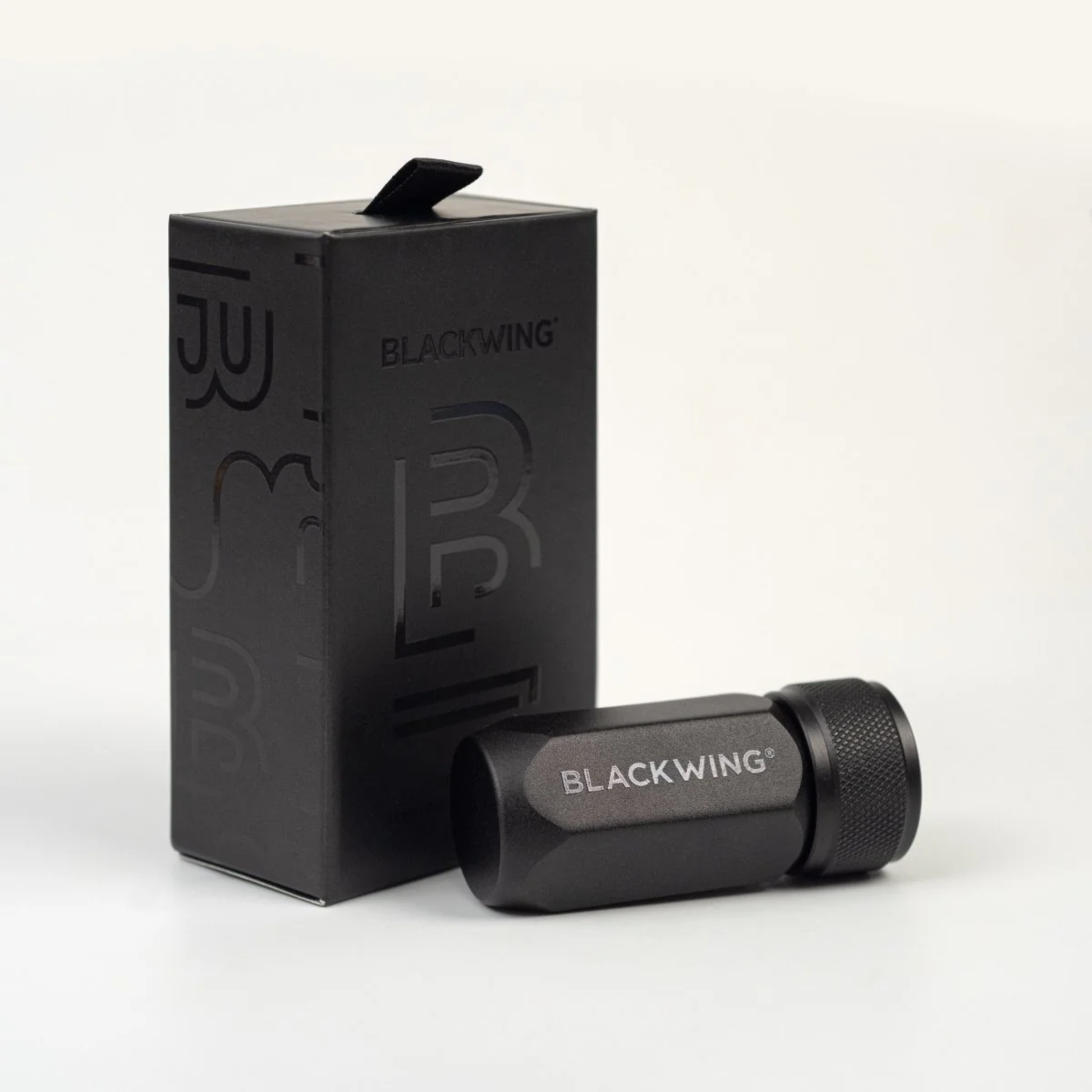 Container box with the Blackwing One-Step Long Point Sharpener in black machined aluminum with German steel blade - compact, pencil sharpener that creates a long curved point resistant to breakage.