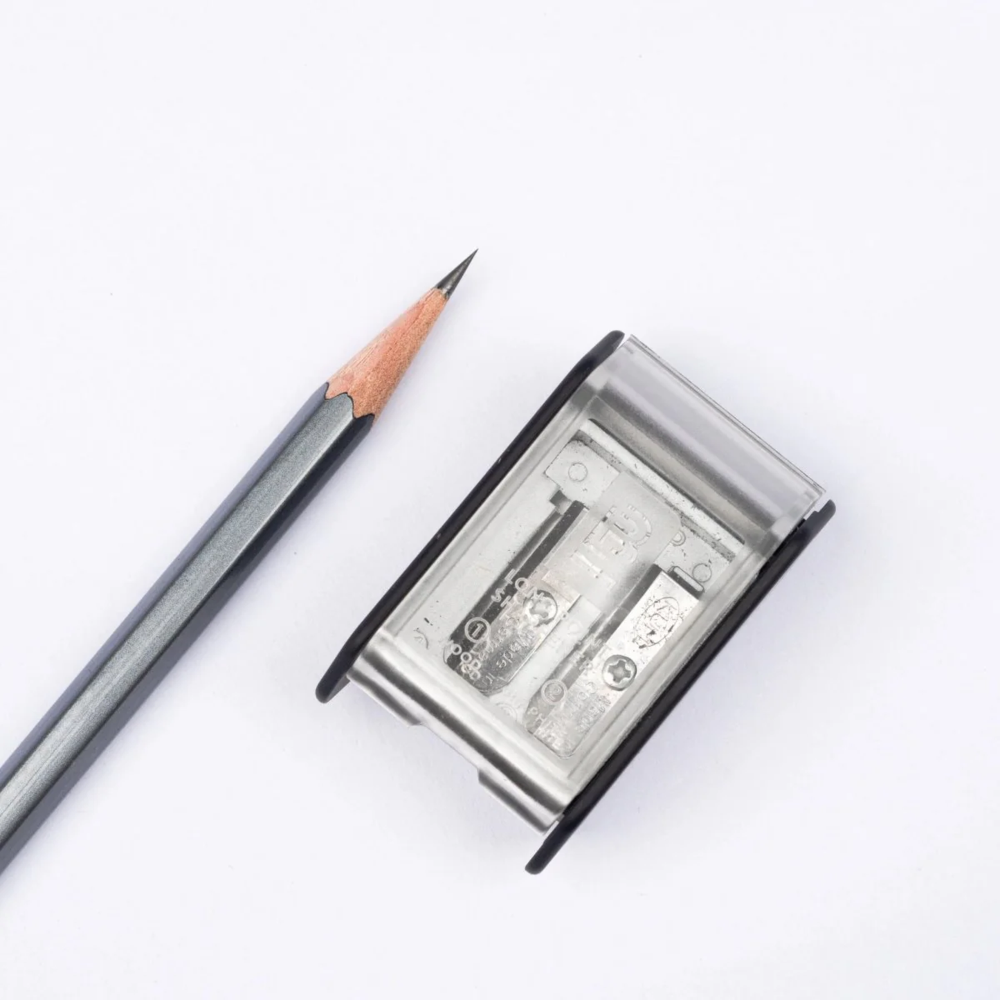 Sharpened black pencil with the Blackwing Two-Step Long Point Sharpener in black with rubberized matte finish and German steel blades.