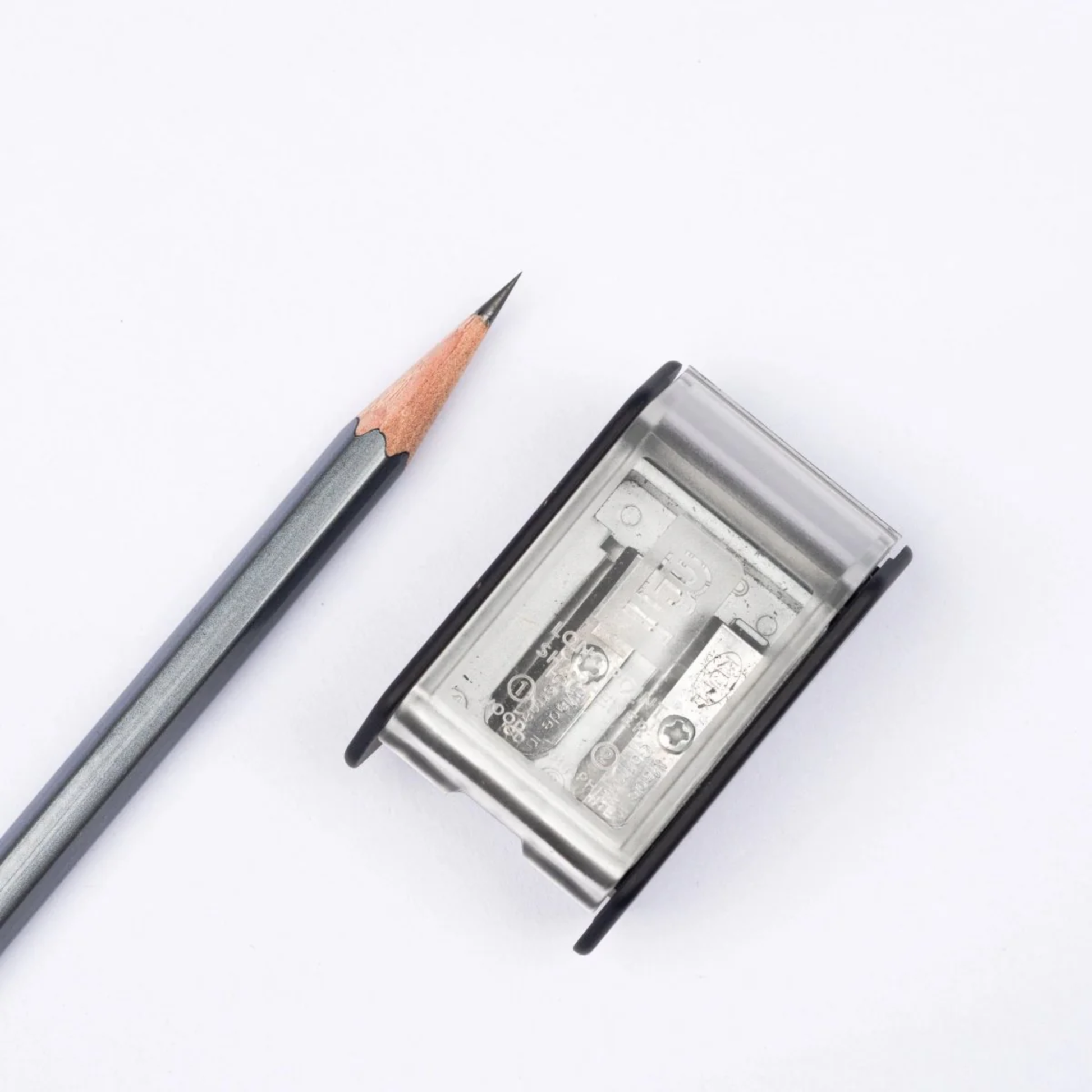 Sharpened black pencil with the Blackwing Two-Step Long Point Sharpener in black with rubberized matte finish and German steel blades.