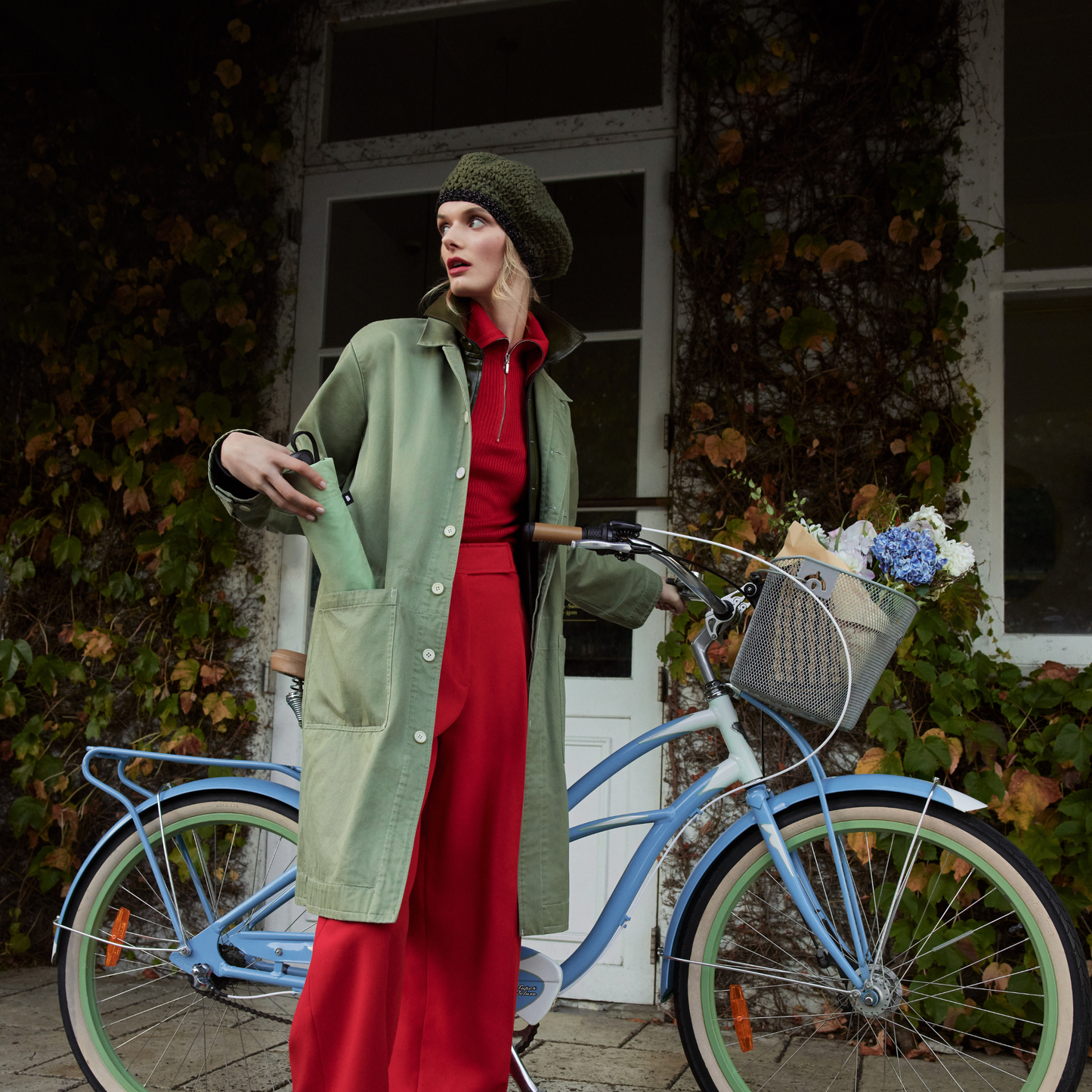 A woman putting the folded Blunt Umbrella Sage Green inside her jacket pocket, that features a compact design with high tensioned canopy, wind tested construction and recycled rPET fabric for rain or shine.