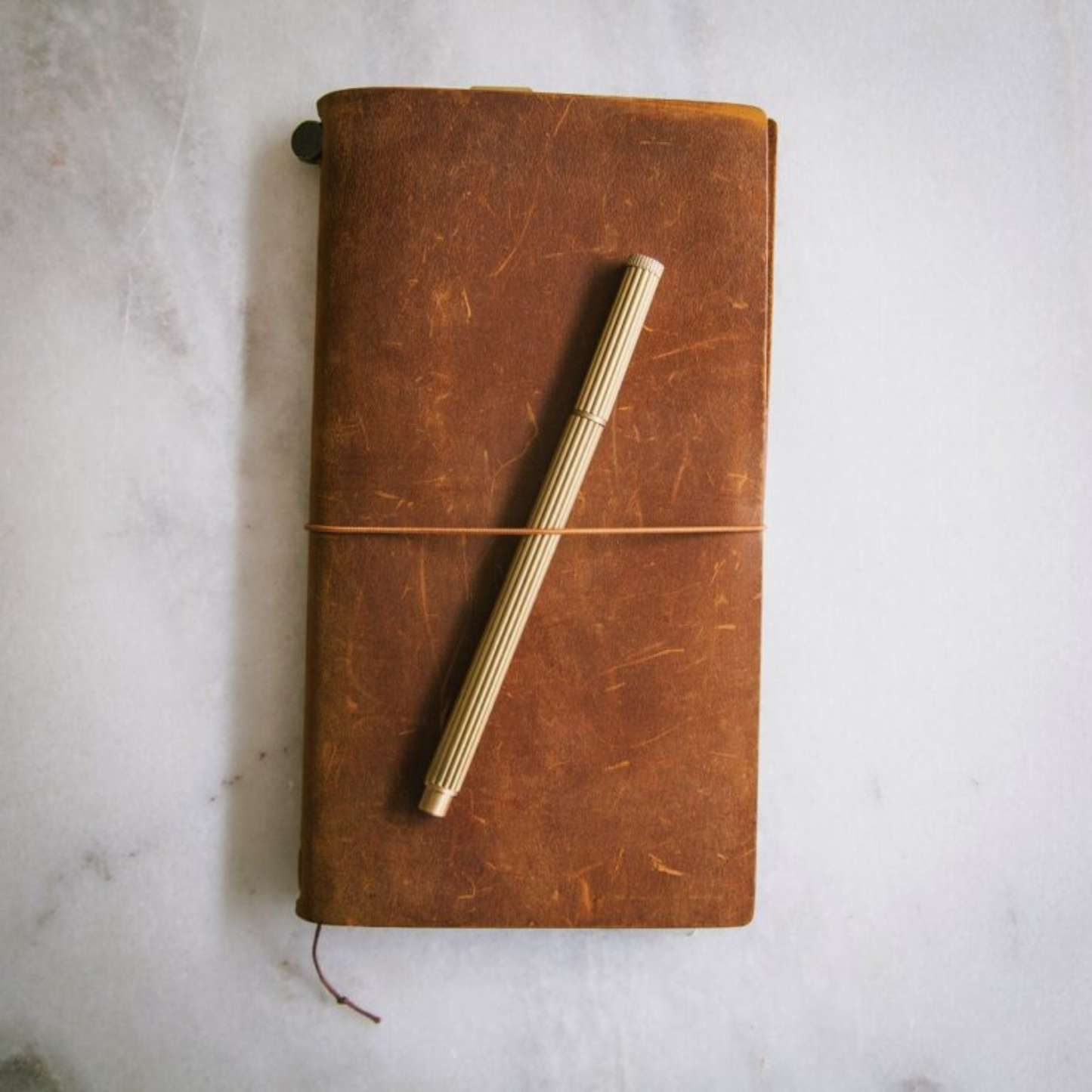 Shown with a notebook Brut Homeware luxury brass pen with a gold-toned finish, refillable Schmidt P900 ink, and black gift box - a heavyweight handmade writing tool ideal for gifting or desk display.