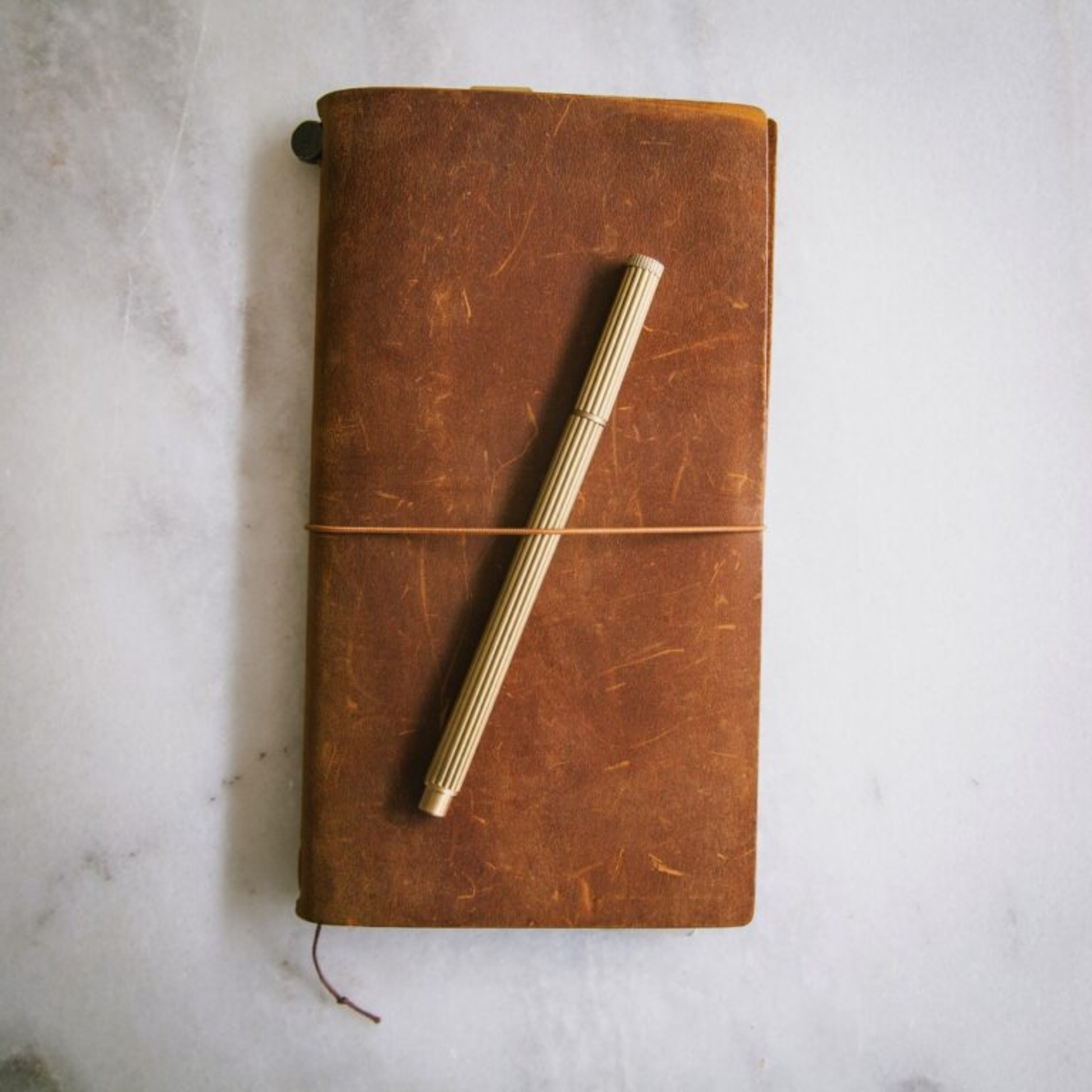 Shown with a notebook Brut Homeware luxury brass pen with a gold-toned finish, refillable Schmidt P900 ink, and black gift box - a heavyweight handmade writing tool ideal for gifting or desk display.