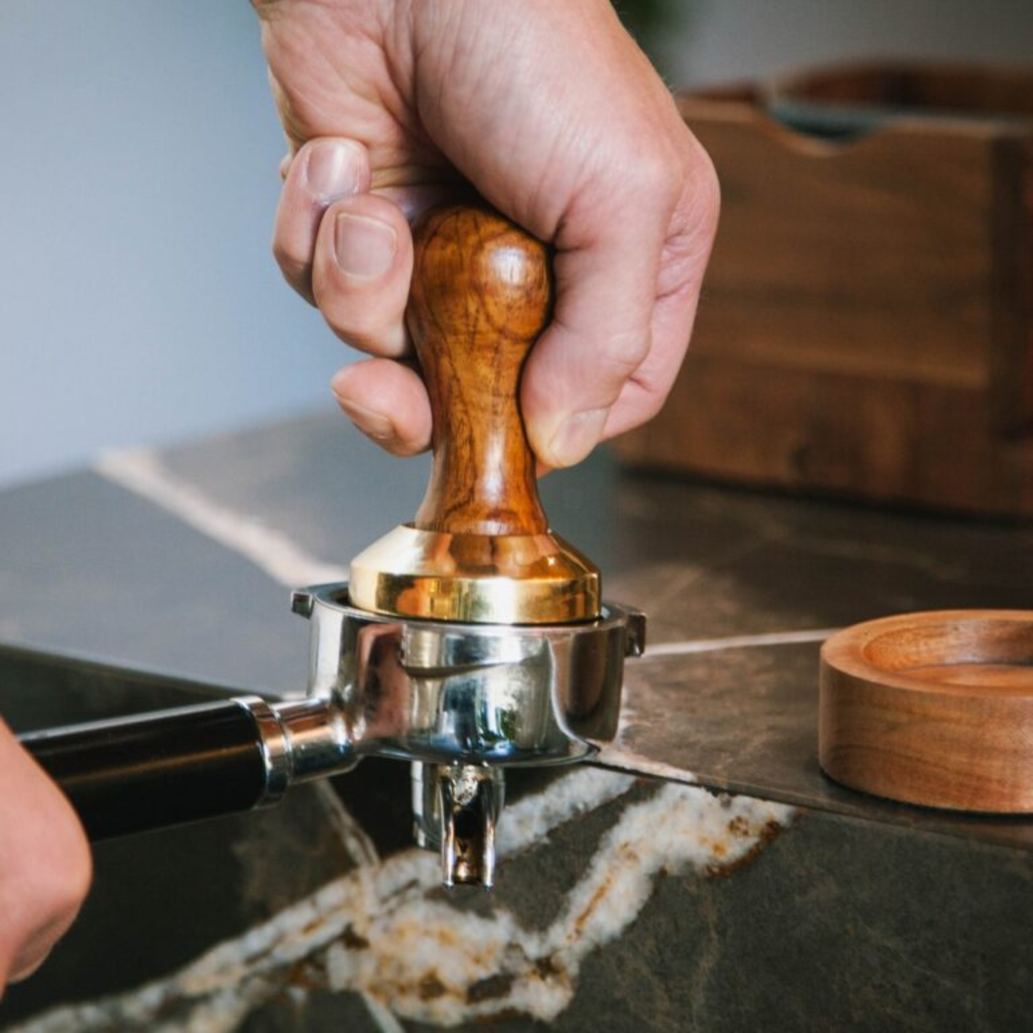 Shown in use Brut Homeware espresso tamper set crafted from acacia wood and brass, precision-weighted at 360 g with a 58 mm base for perfect espresso tamping, elegantly packaged in a black gift box - ideal for coffee lovers and baristas.