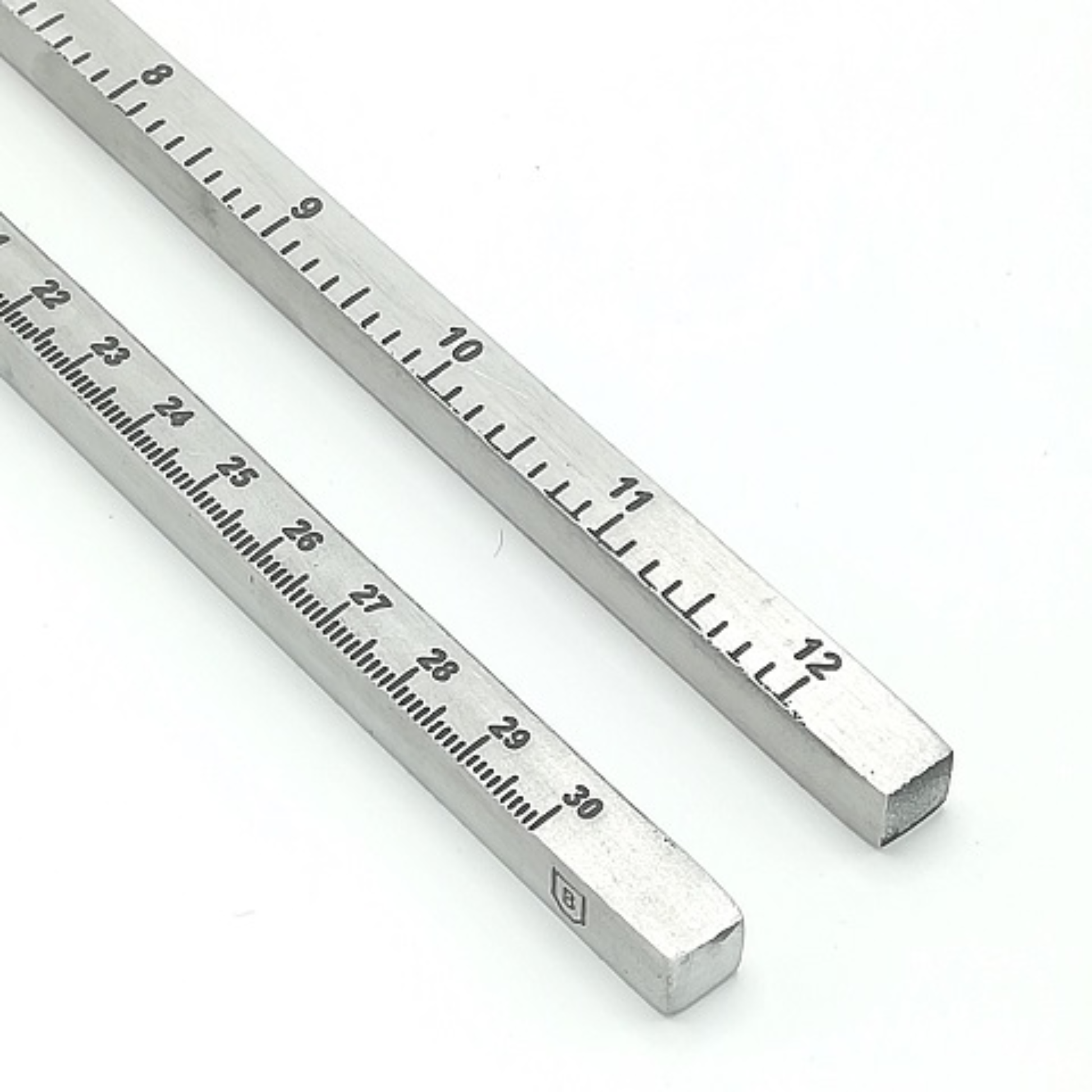 Close up of the Brut Homeware aluminium measuring rod featuring dual metric and imperial scales, 30 cm / 12 in long, lightweight and precision-made, packaged in a black carton-ideal for designers, artists, and stationery lovers seeking a sleek, durable tool.