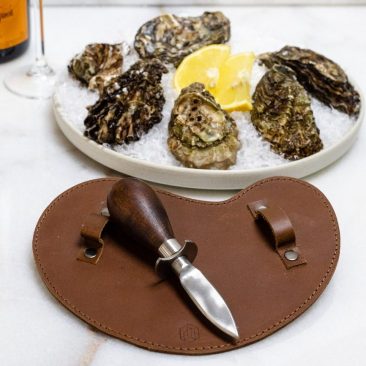 Shown with oysters Brut Homeware classic oyster knife set featuring a stainless steel knife with acacia wood handle and a thick buffalo leather safety glove, presented in a black box-an elegant and durable toolset for seafood enthusiasts.