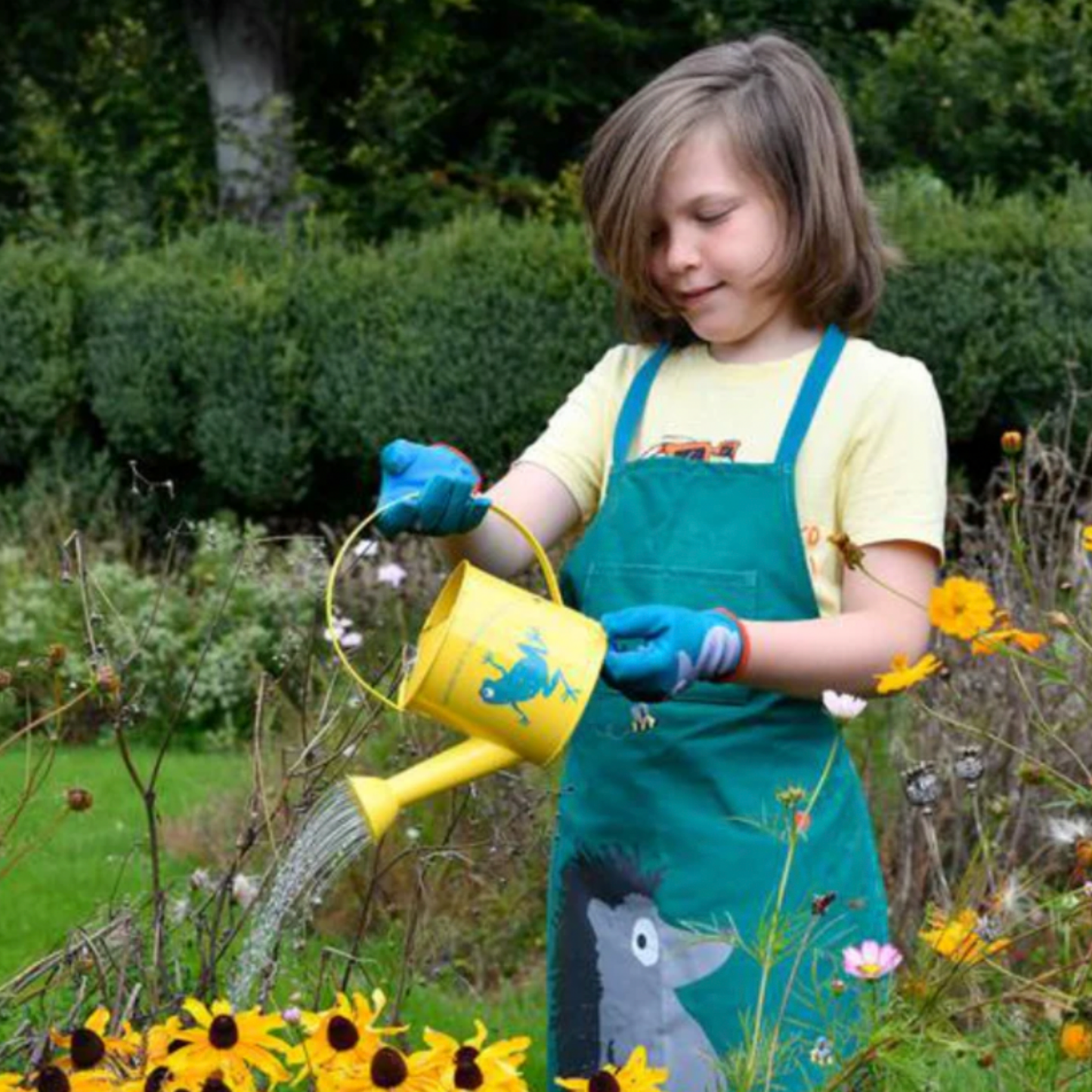 Kid using Burgon & Ball national trust kids watering can in flower patch