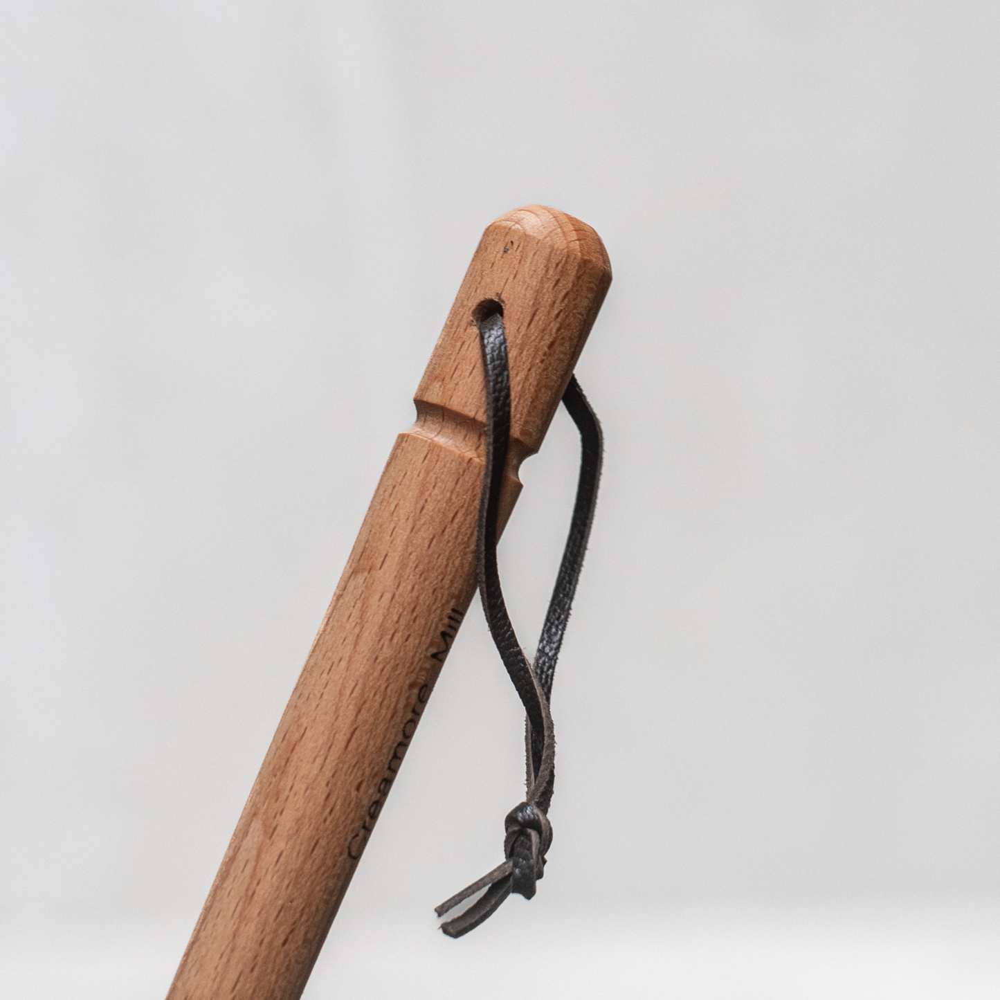 Wooden handle with the hanging loop at the bottom from Fathom natural leather fly swatter with beechwood handle, 53cm durable and gentle insect control tool for kitchens, patios, and outdoor dining.