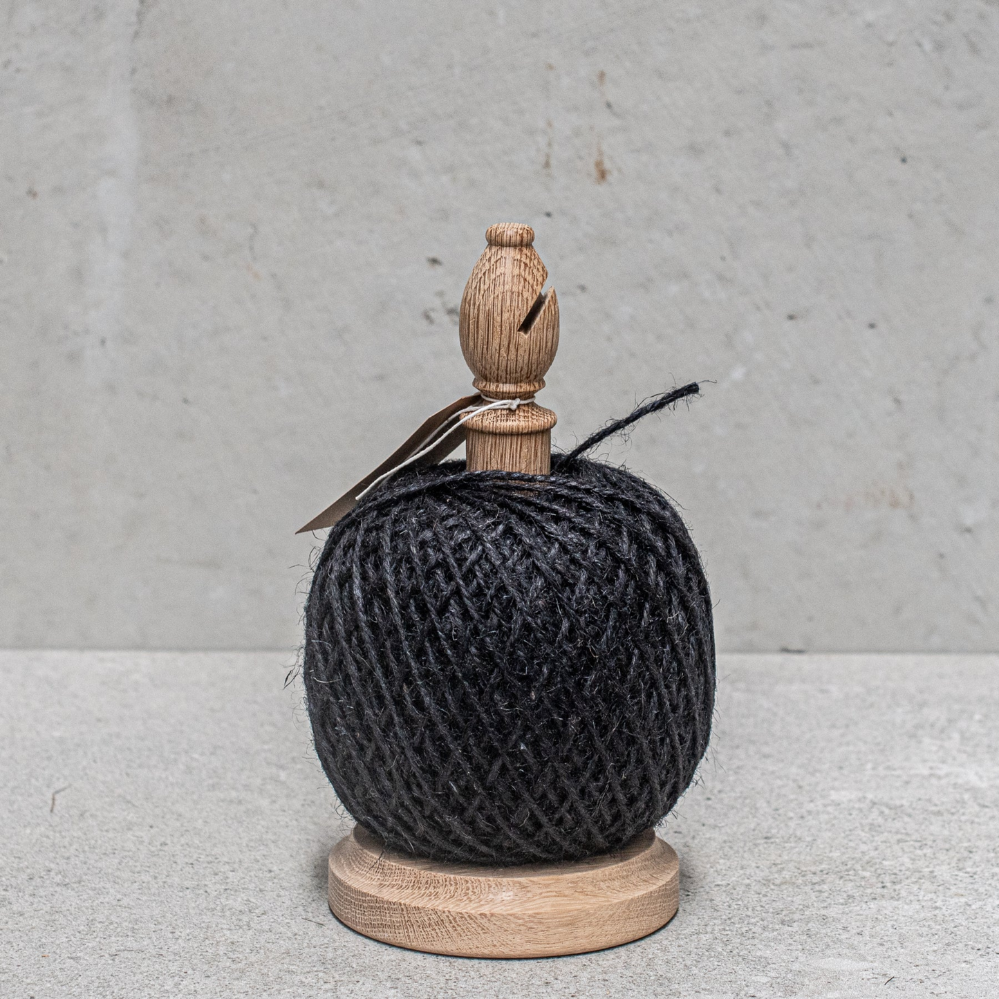 Twine stand with cutter black front view on concrete table