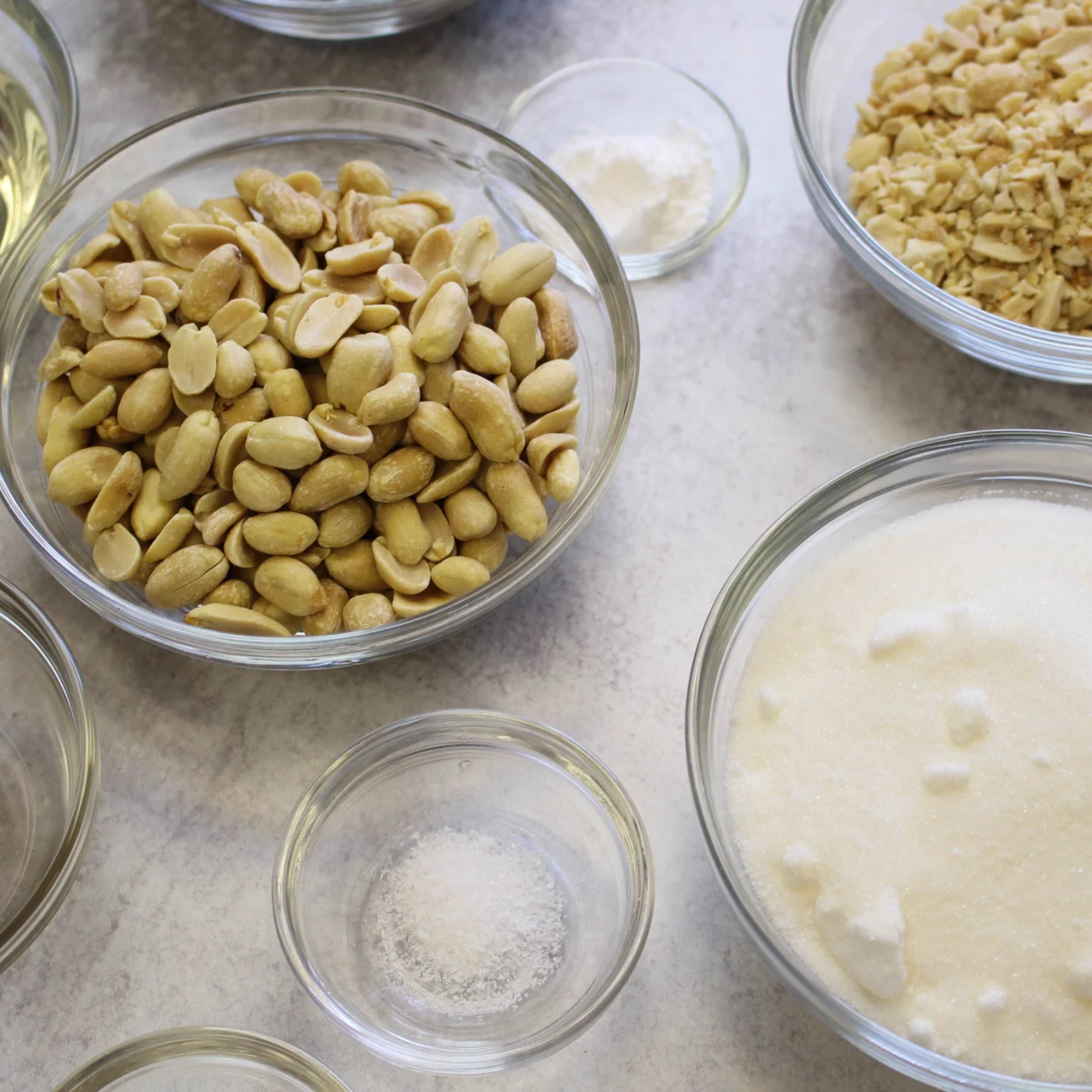 Duralex Le Gigogne stackable transparent glass salad bowl, shown with nuts in it, 2.4 L - 23 cm, rounded shape, ideal for salad, punch, or sauce.