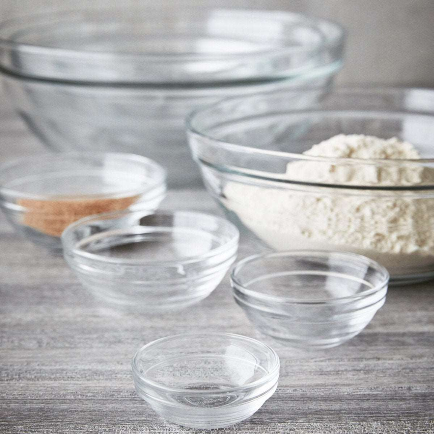 Clear Duralex transparent glass bowl with rounded shape, stackable design, shown with other sizes for difference, 12.5cl - 9cm, ideal for sauce, dip, small dessert, snacks and fruits.
