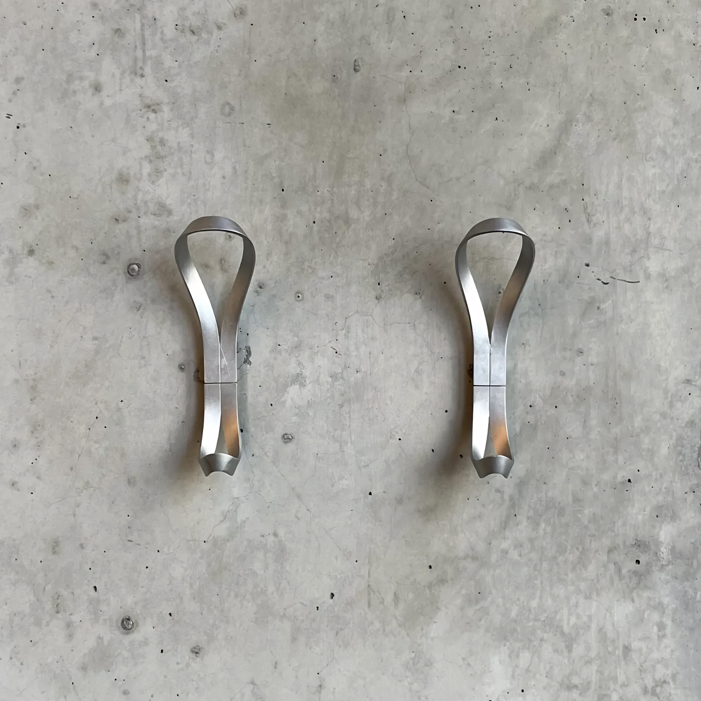 Two Essem Endless Hook Aluminium designed by Anna von Schewen, from recycled aluminum hung on the wall.