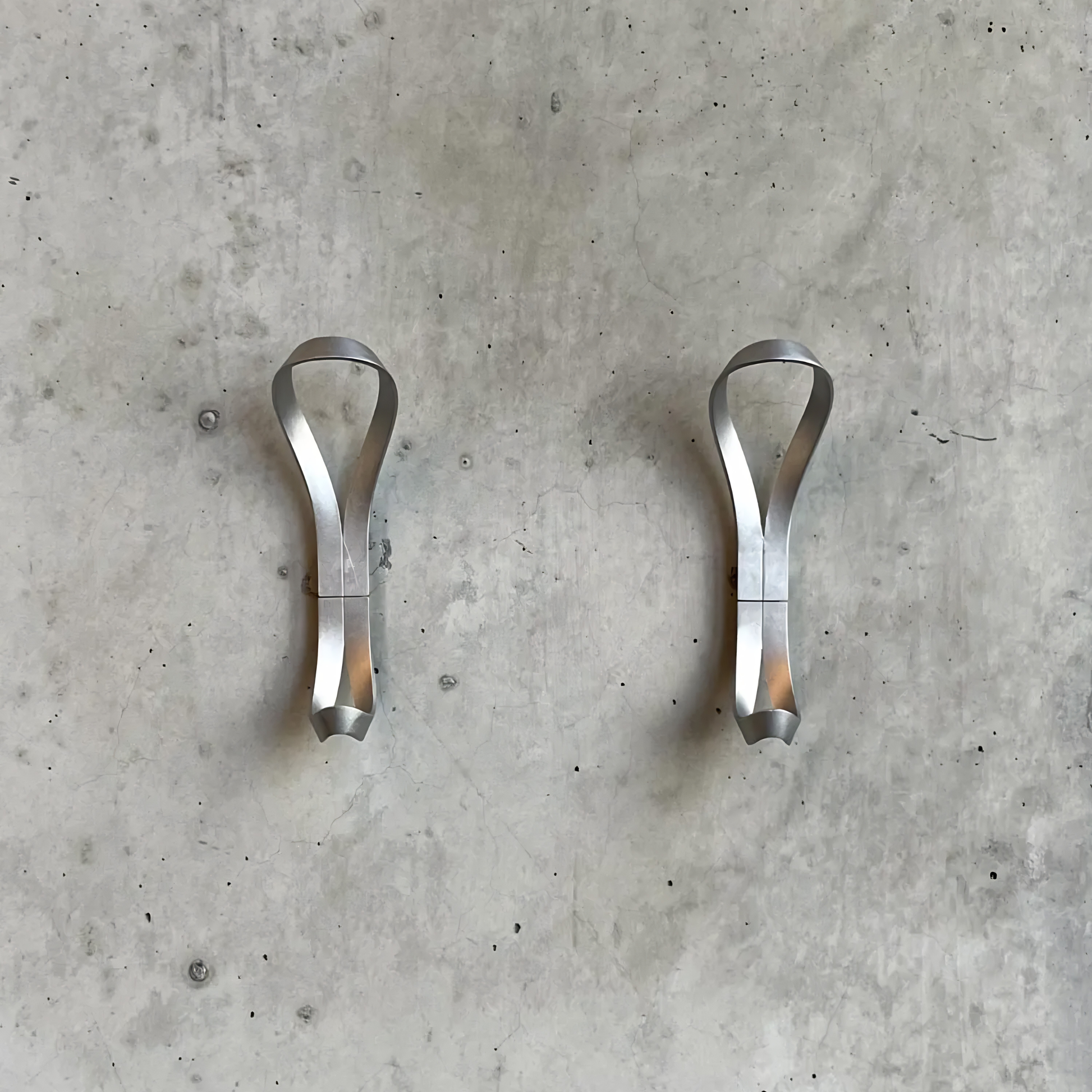 Two Essem Endless Hook Aluminium designed by Anna von Schewen, from recycled aluminum hung on the wall.