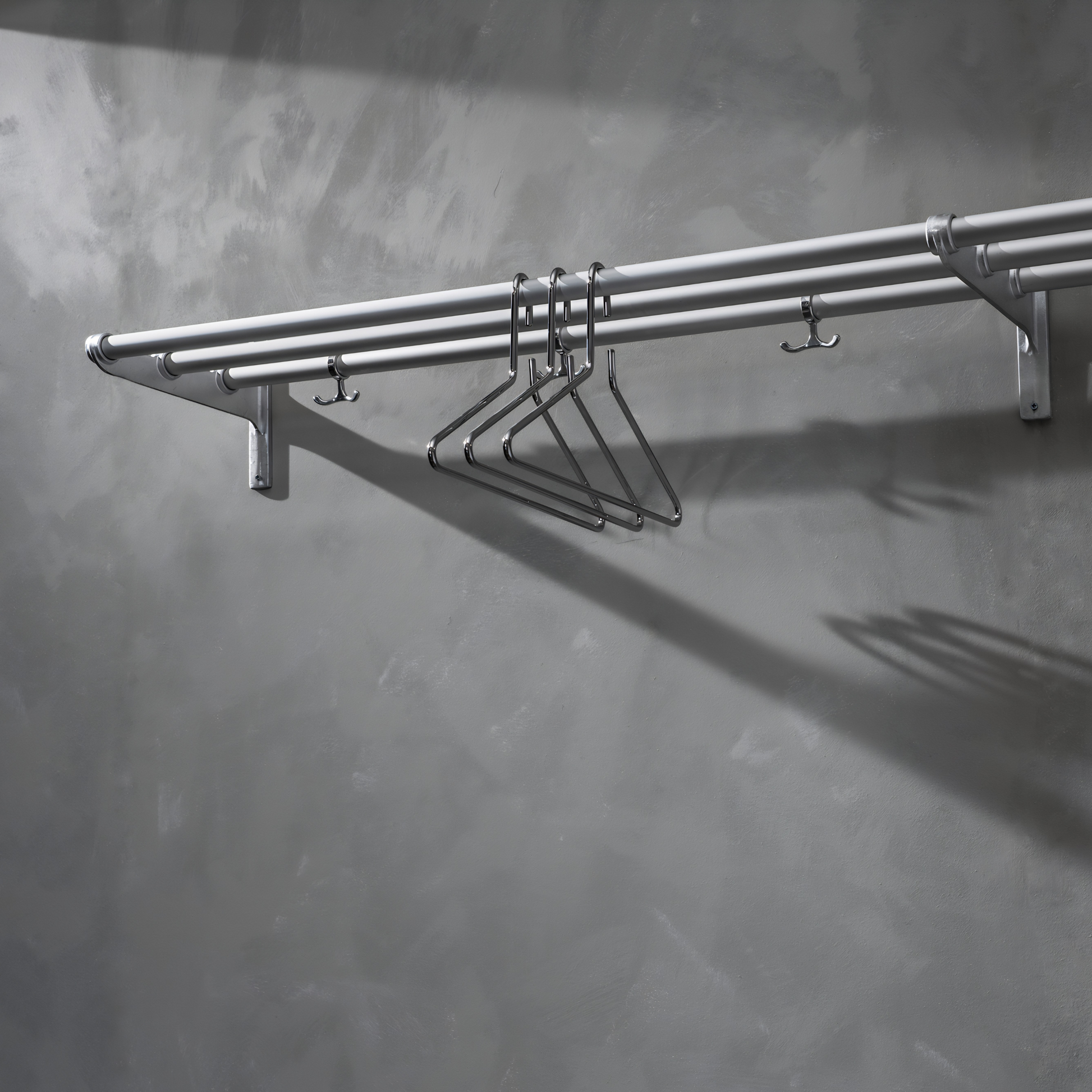 Shown hung on the wall, the Essem Nostalgi Rack Oak designed by Gunnar Bolin, the brackets are made of recycled aluminum with a wooden or aluminum bar, can be extended and with anchor hooks.