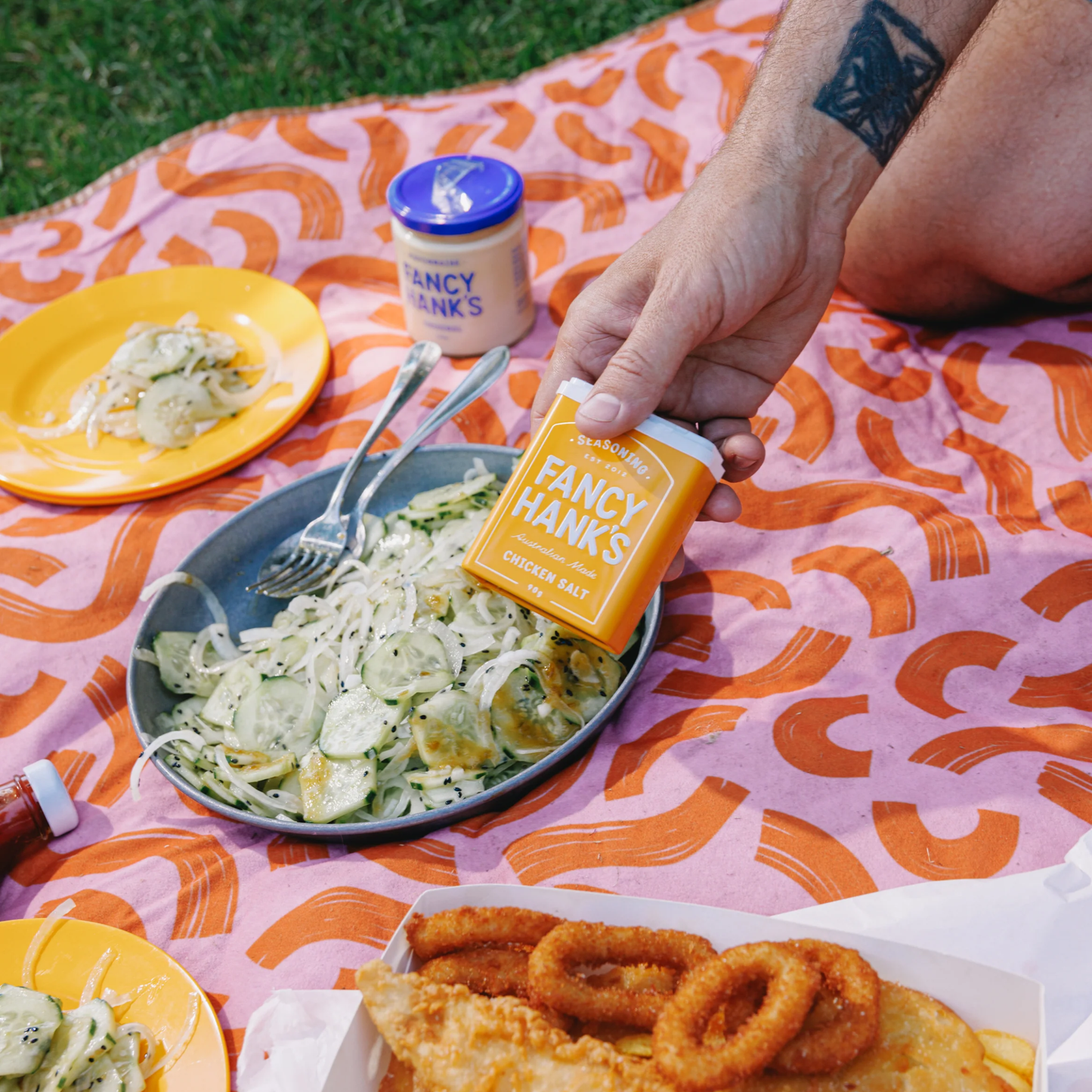 Showing the Fancy Chicken Salt 90g, on a picnic setting, a savoury blend, vegan friendly made with real vegetable powders, spices and yeast extract.